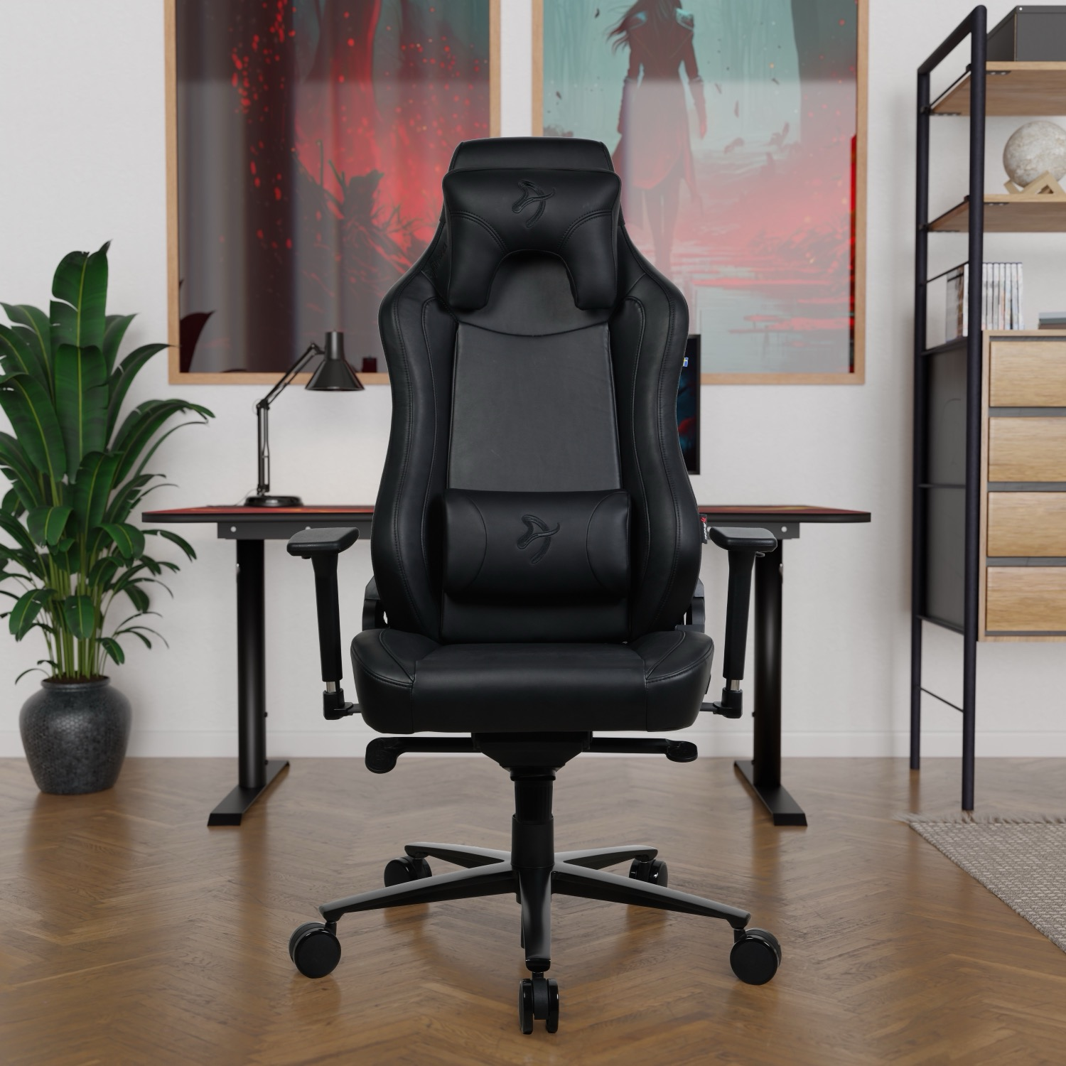 Een zwarte gamestoel voor een bureau met twee schilderijen aan de muur.