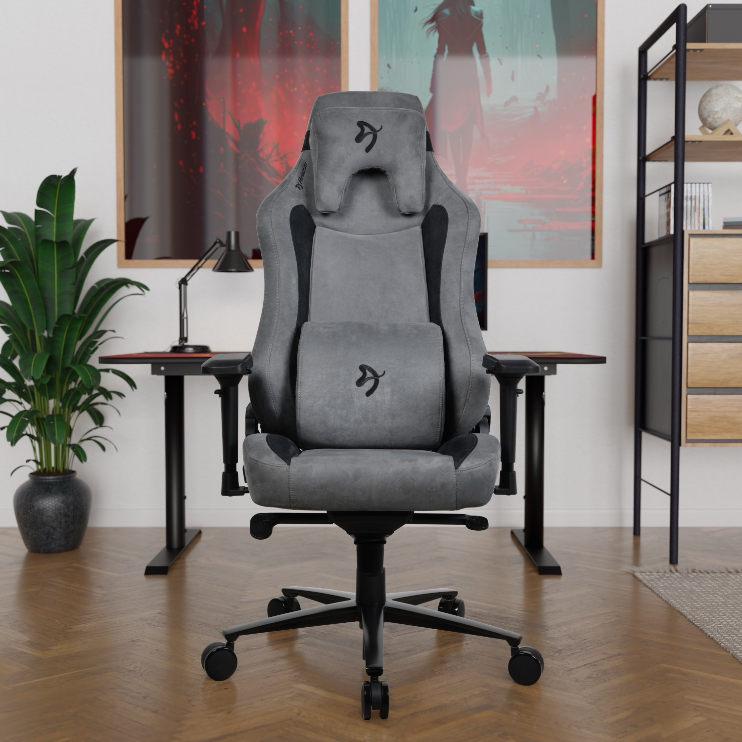 Grijze gamestoel met hoofdsteun en lendenkussen voor een bureau.