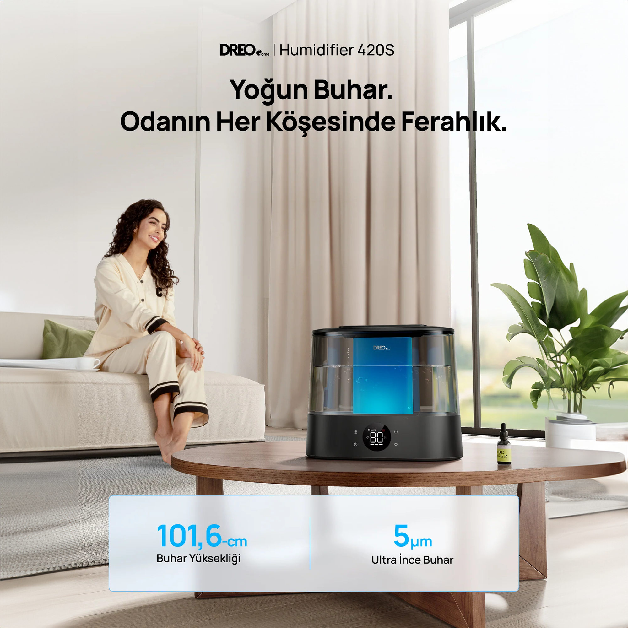 Kadın koltukta oturuyor, yanında masada bir nemlendirici var.