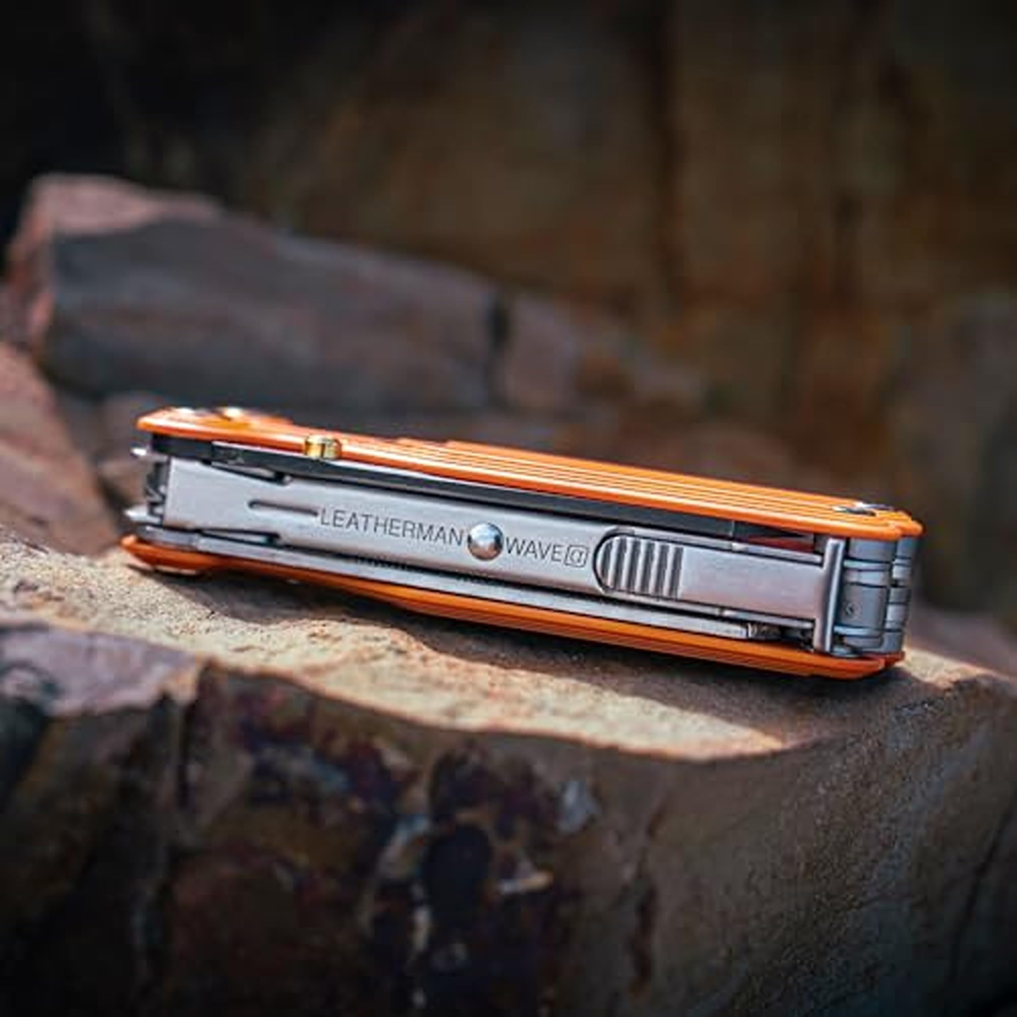Ein orangefarbenes Leatherman Wave Multitool liegt auf einem Felsen.