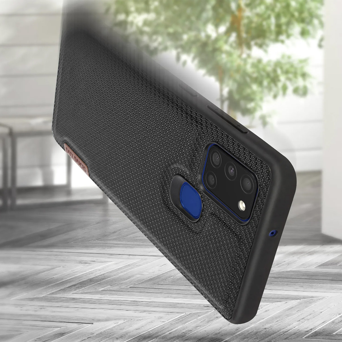 Cover nera per telefono con sistema di fotocamere e sensore di impronte su pavimento in legno.