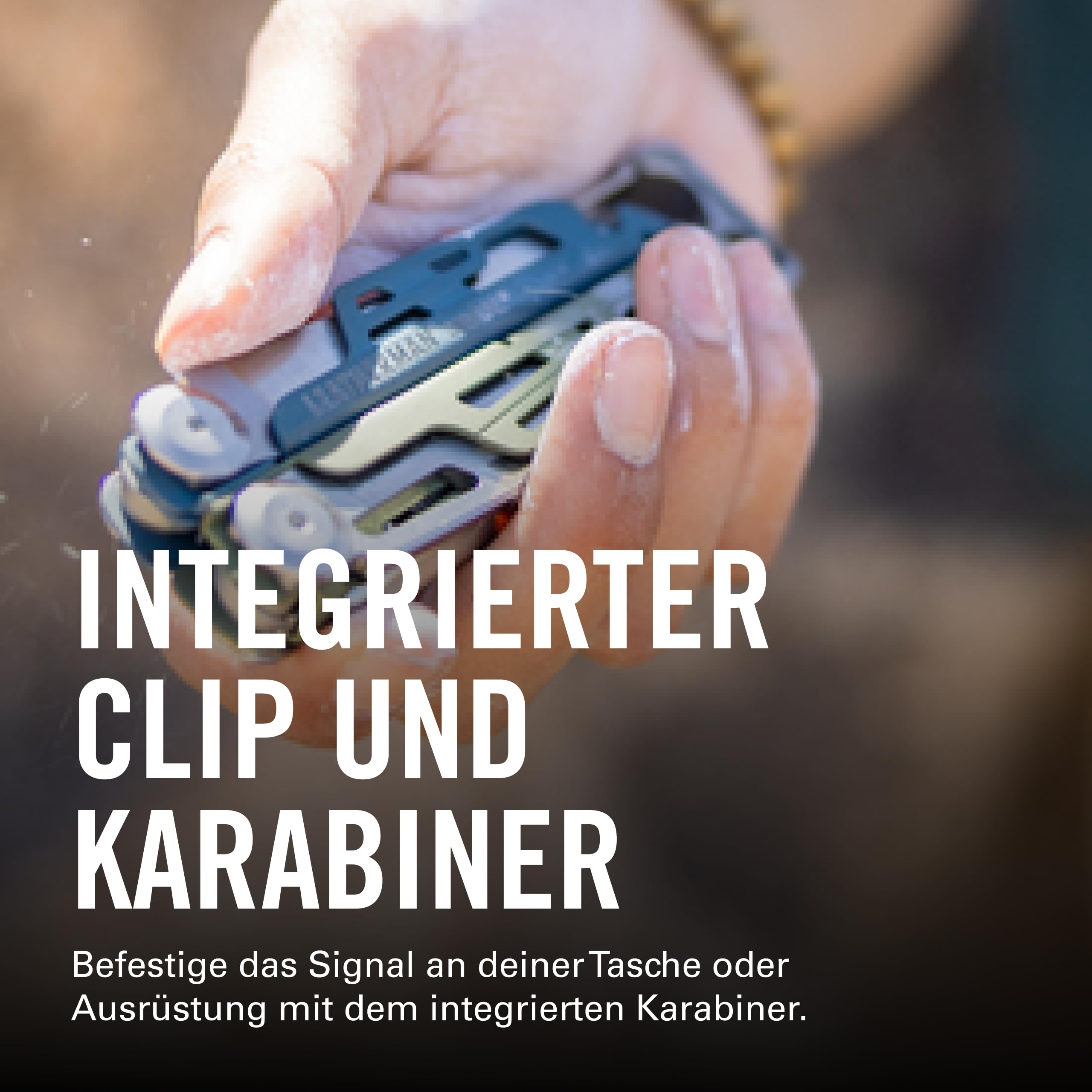 Eine Hand hält ein Werkzeug mit integriertem Clip und Karabiner.