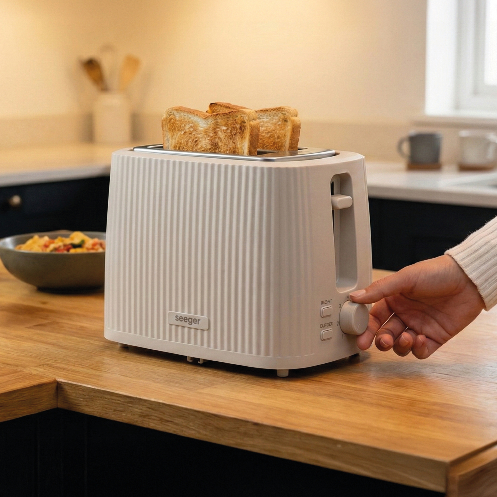 Un grille-pain beige avec trois tranches de pain grillé sur un comptoir en bois.