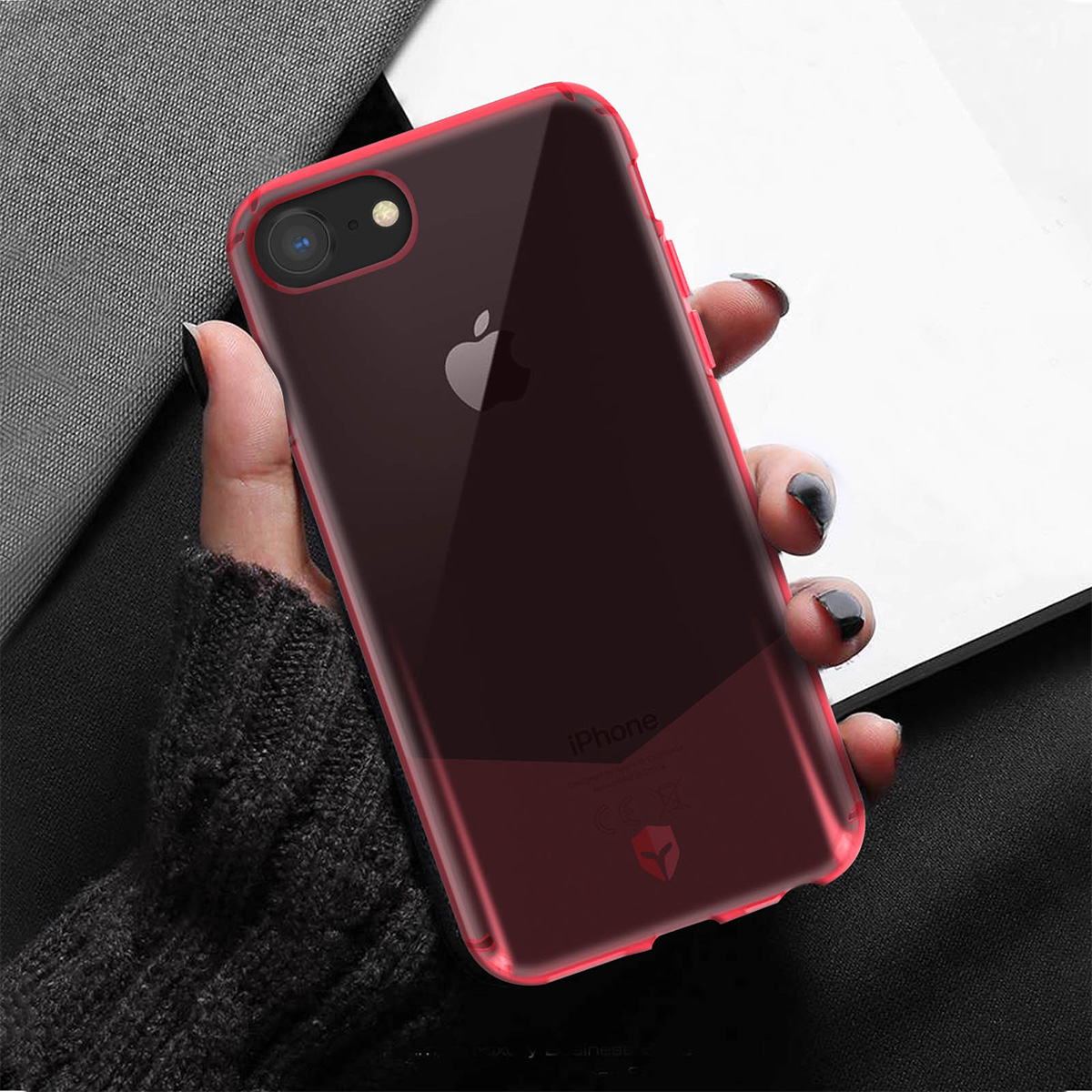 Une main tient un iPhone sombre et transparent avec un bord rouge.
