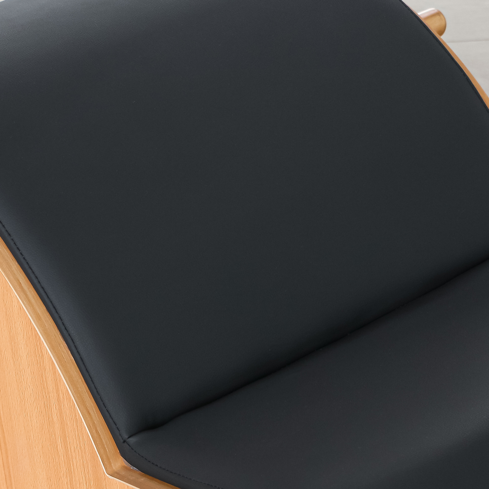 Primo piano di una seduta nera per sedia con telaio in legno.