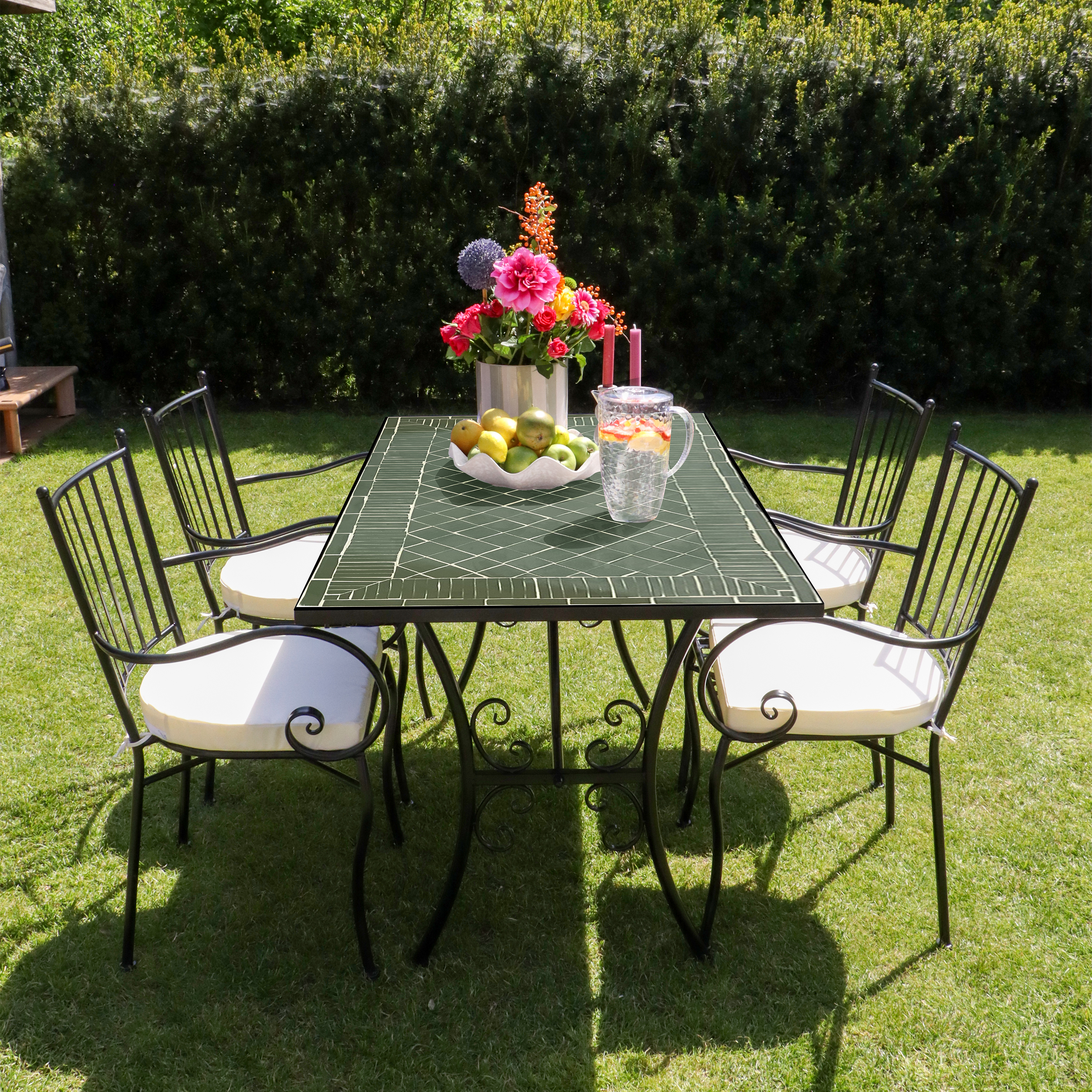 Ein Gartentisch mit vier Stühlen und Blumen auf dem Rasen.