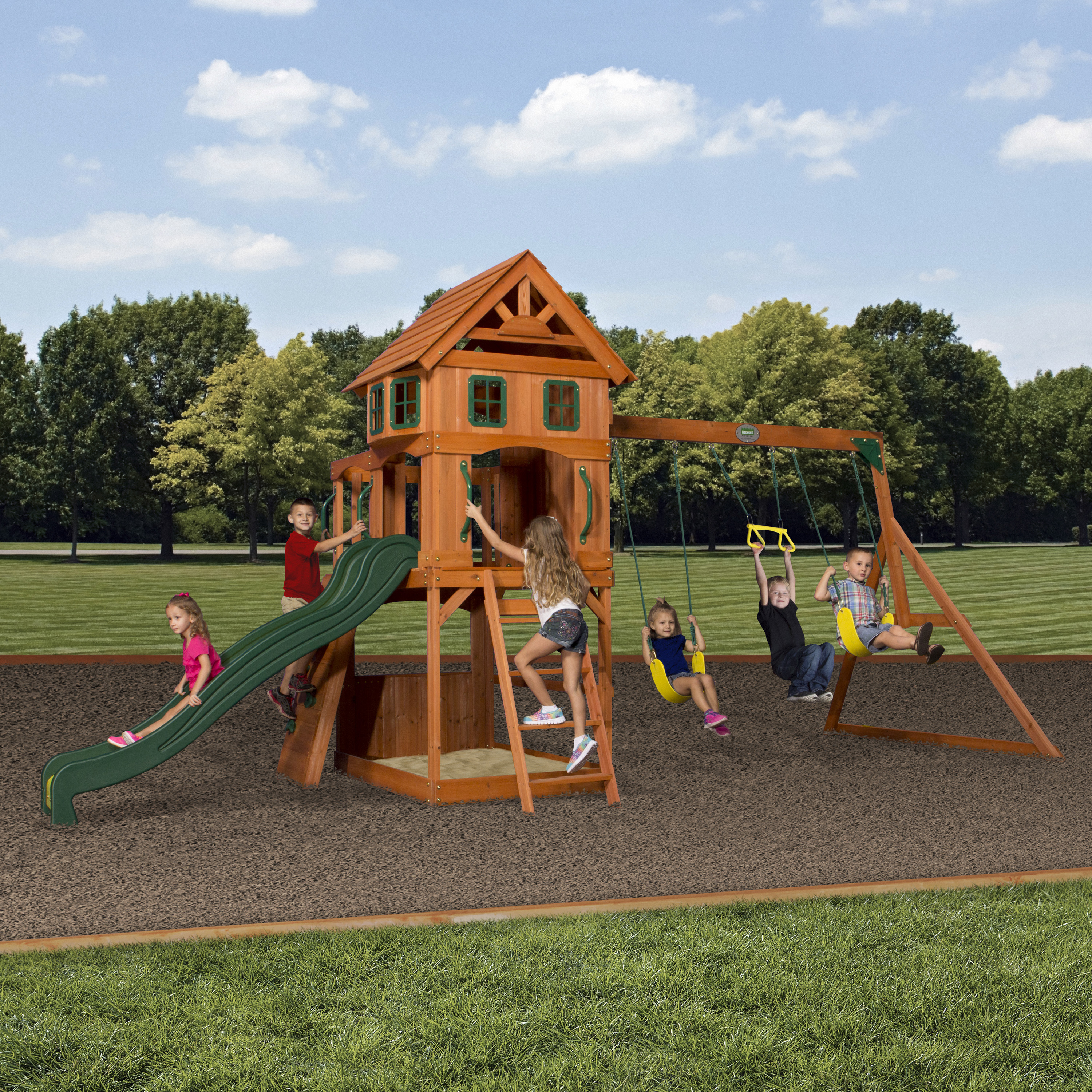 Kinder spielen auf einem Holzspielturm mit Rutsche und Schaukeln.