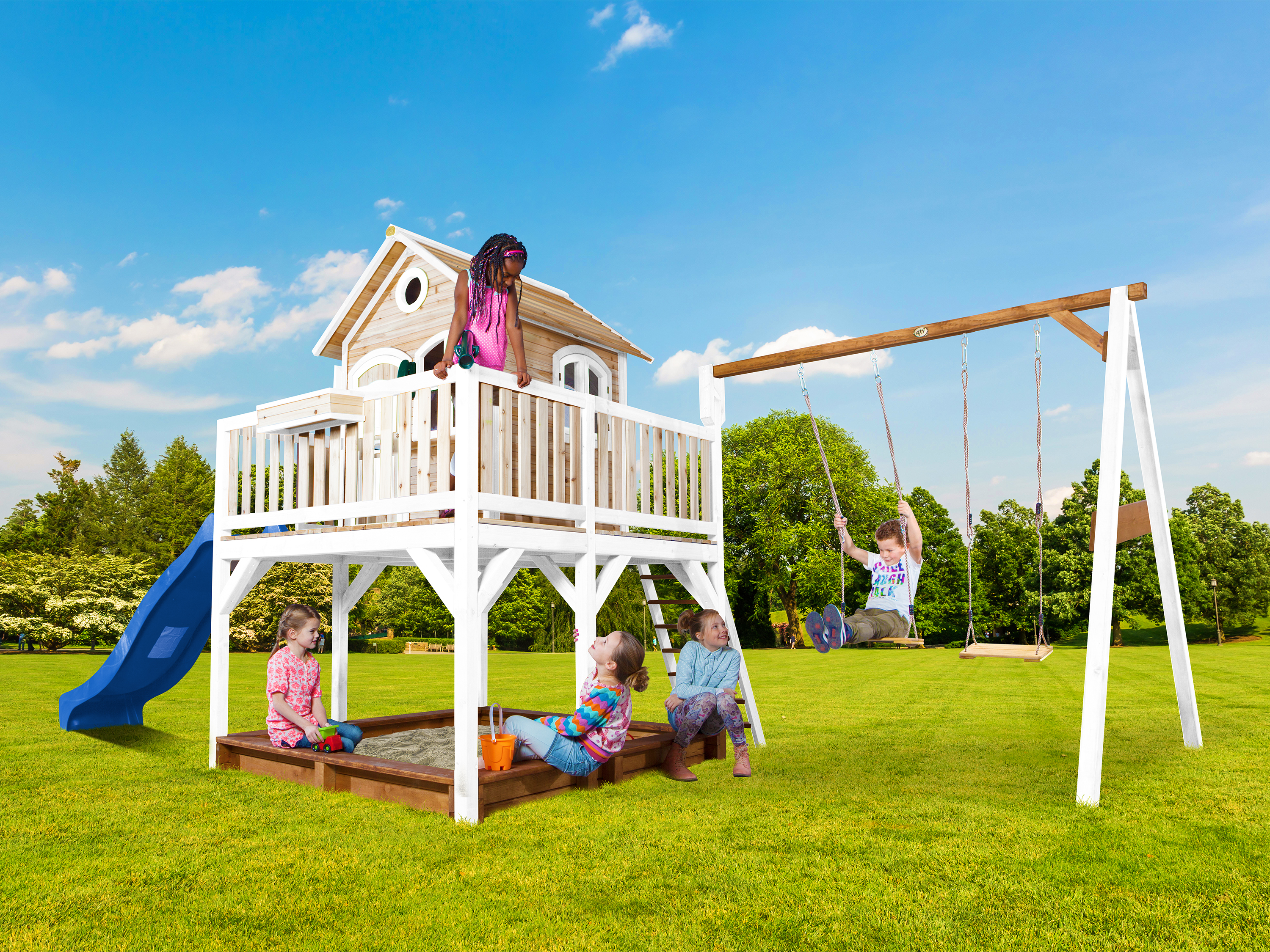 Kinder spielen auf einem Spielgerät mit Rutsche und Schaukeln im Garten.