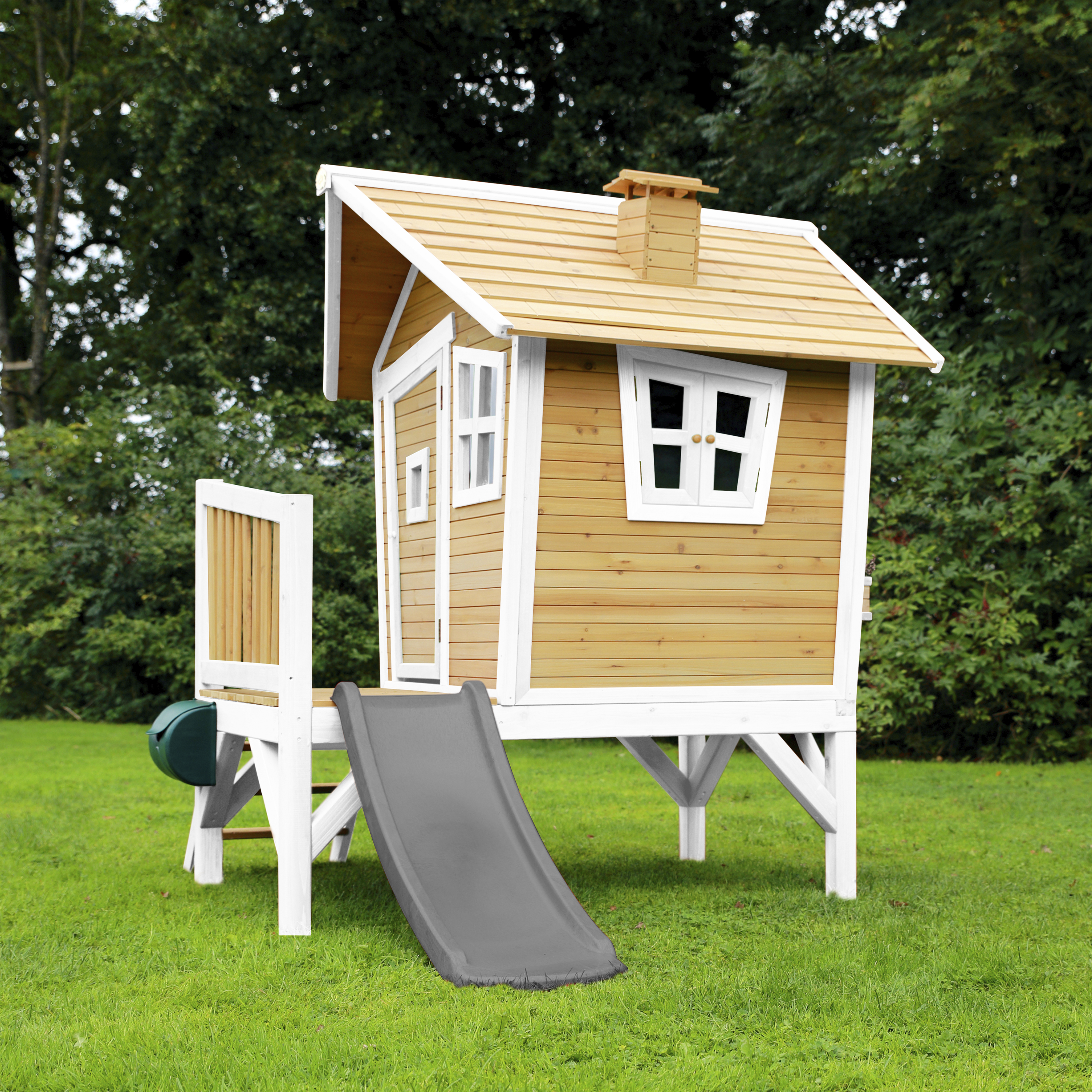 Ein hölzernes Spielhaus mit Rutsche im Garten