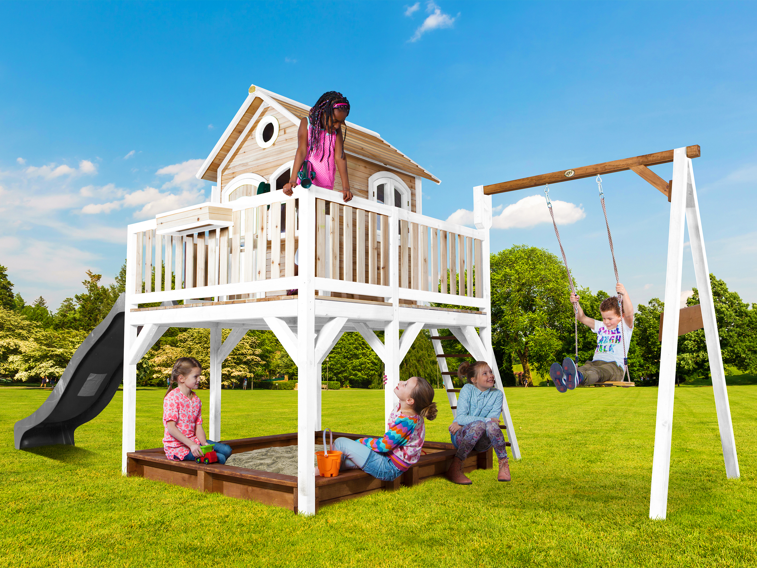 Kinder spielen auf einem Spielturm mit Rutsche und Schaukel im Garten.