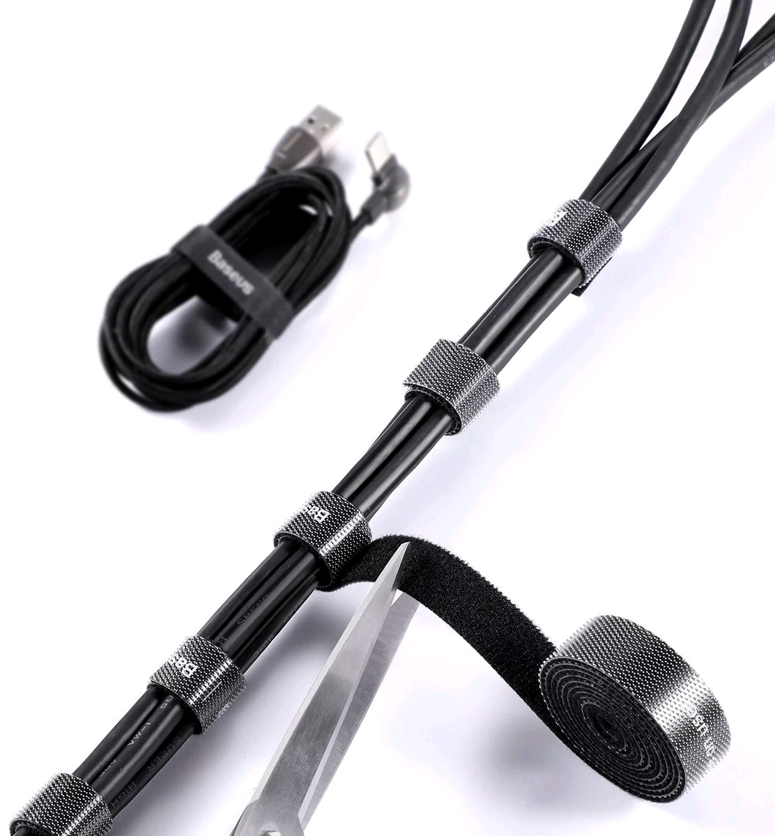 Czarne kable z paskami na rzepy i nożyczkami przecinającymi pasek.