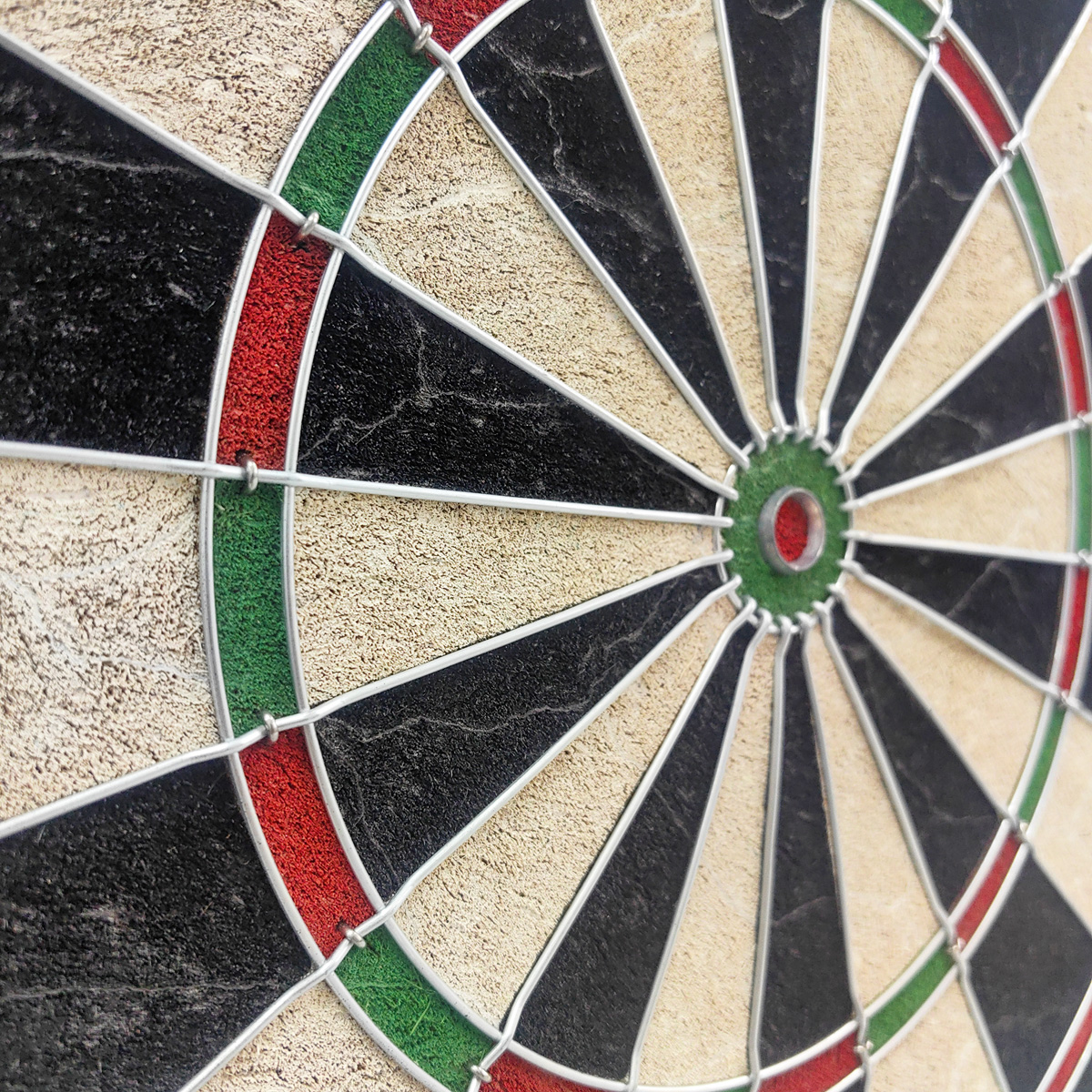 Nahaufnahme einer Dartscheibe mit schwarzen, beigen und roten Segmenten.