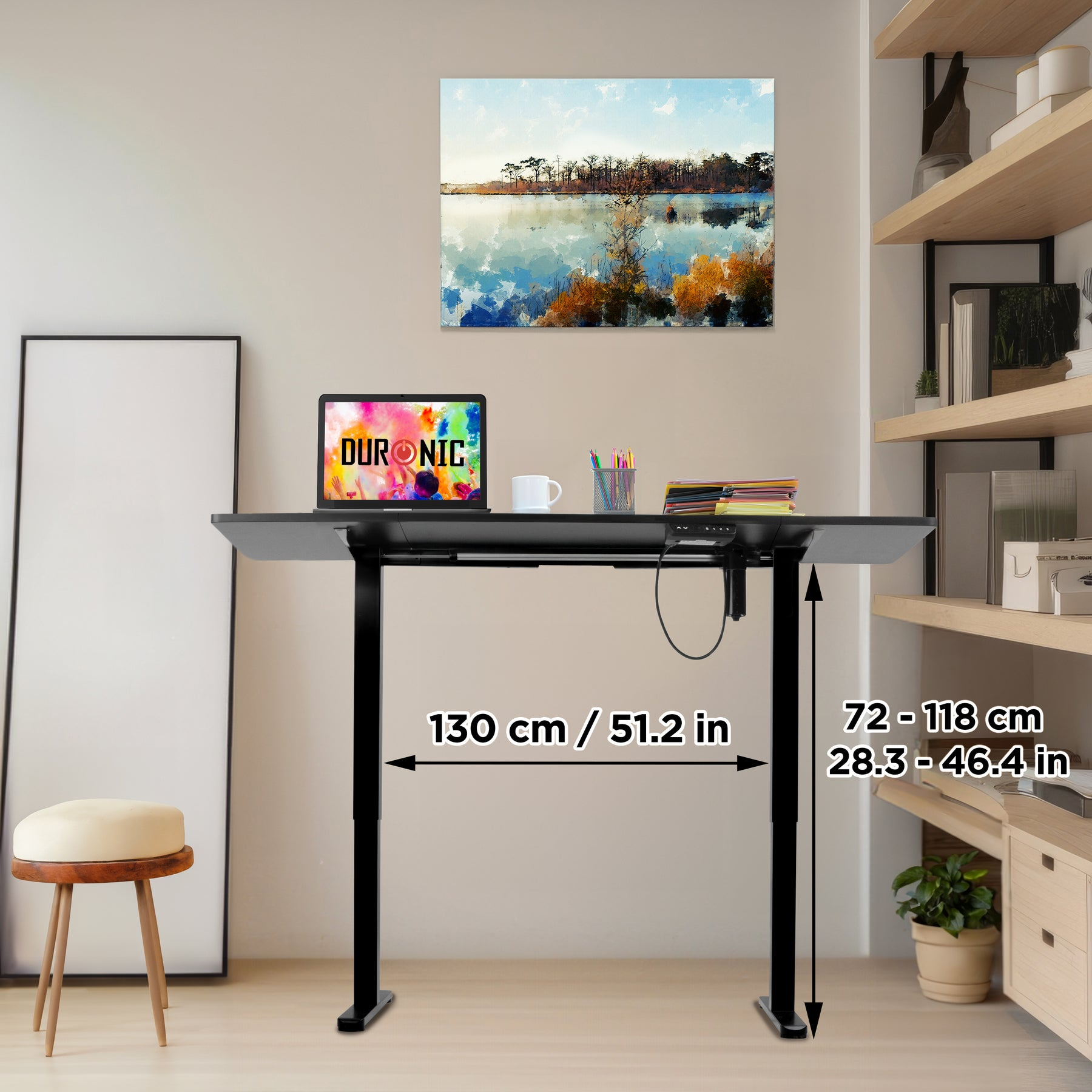Ein Stehschreibtisch mit einem Laptop, einer Tasse und einem Bild von einem See.