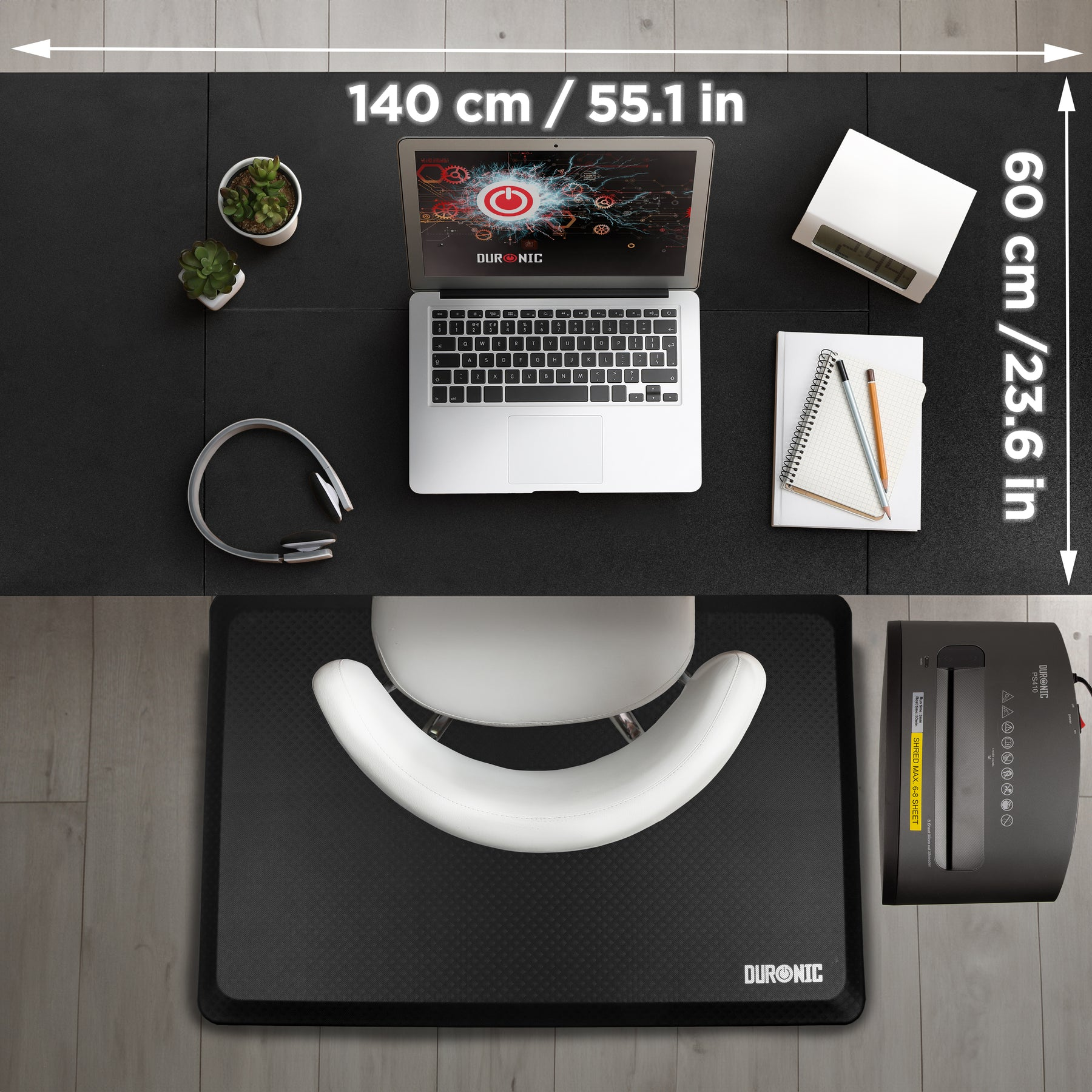 Ein Schreibtisch mit Laptop, Uhr, Pflanzen, Kopfhörern und einem Aktenvernichter.