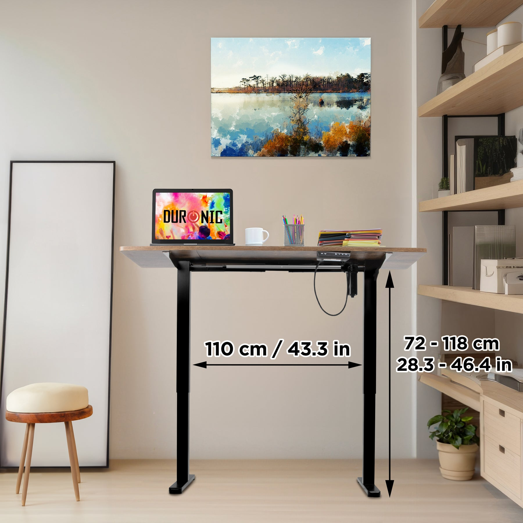 Ein höhenverstellbarer Schreibtisch mit Laptop, Tasse und Stiften. Ein Gemälde im Hintergrund.