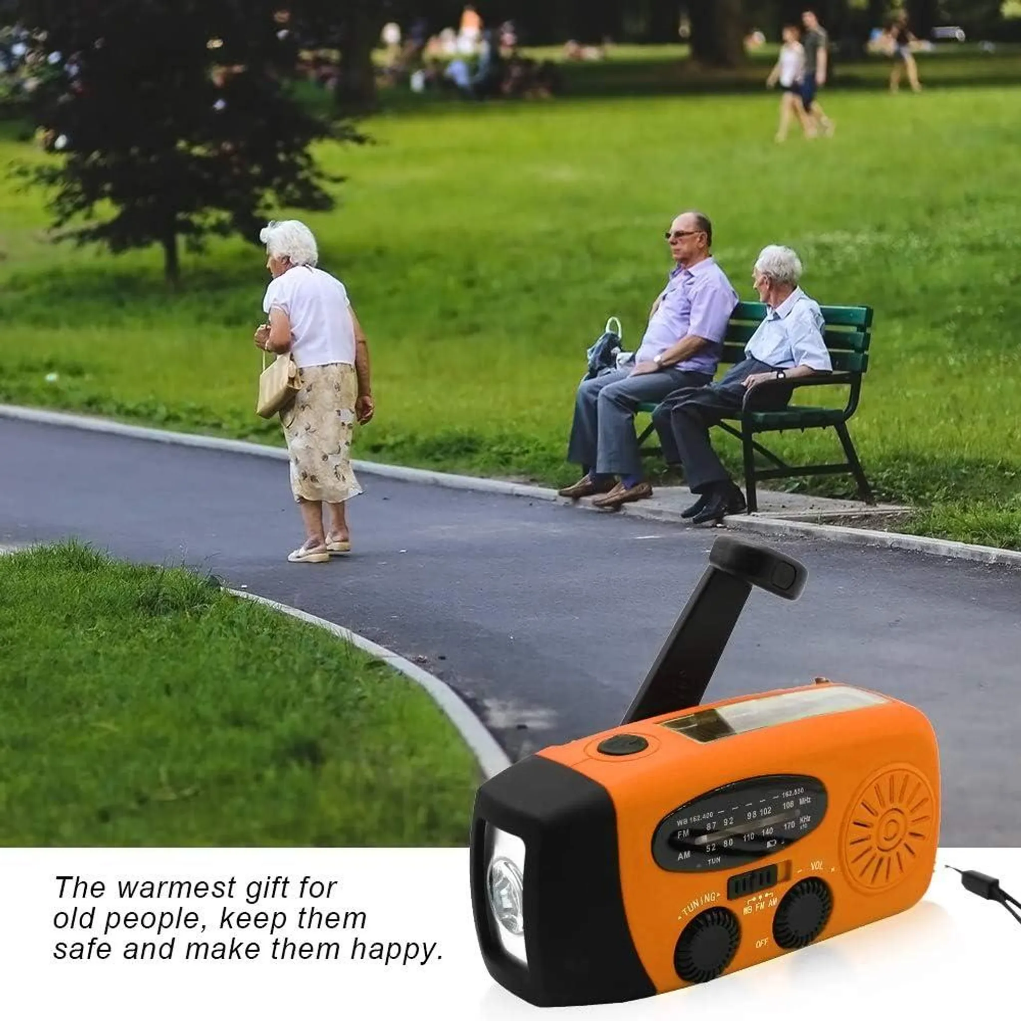 Ein orangefarbenes Radio mit Kurbel und Taschenlampe steht vor einem Park mit Menschen.