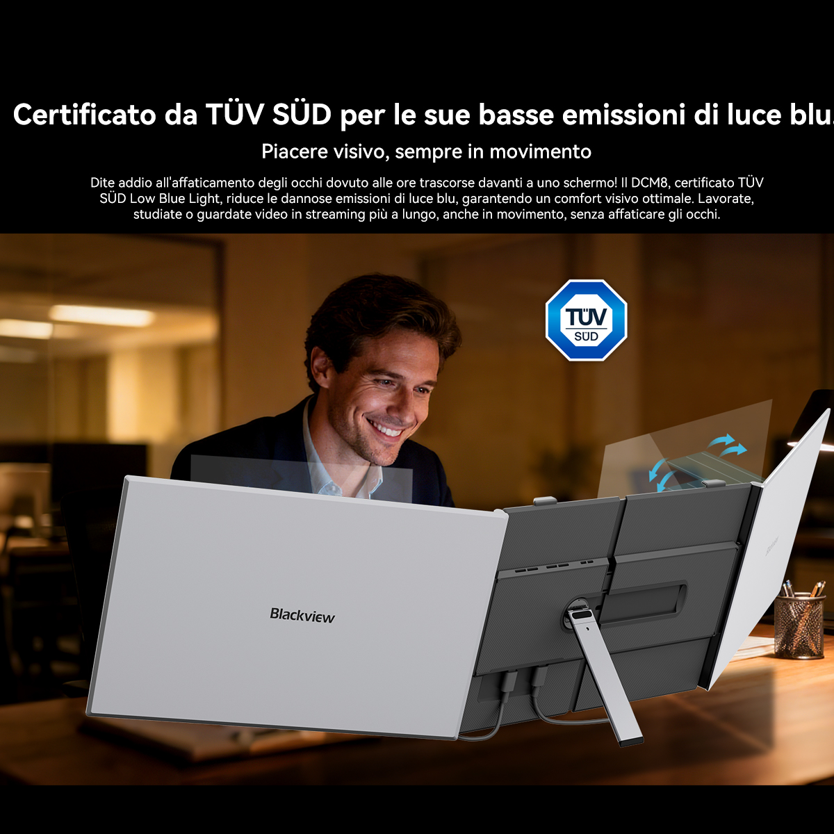 Un uomo sorride guardando un laptop certificato TÜV SÜD per basse emissioni di luce blu.