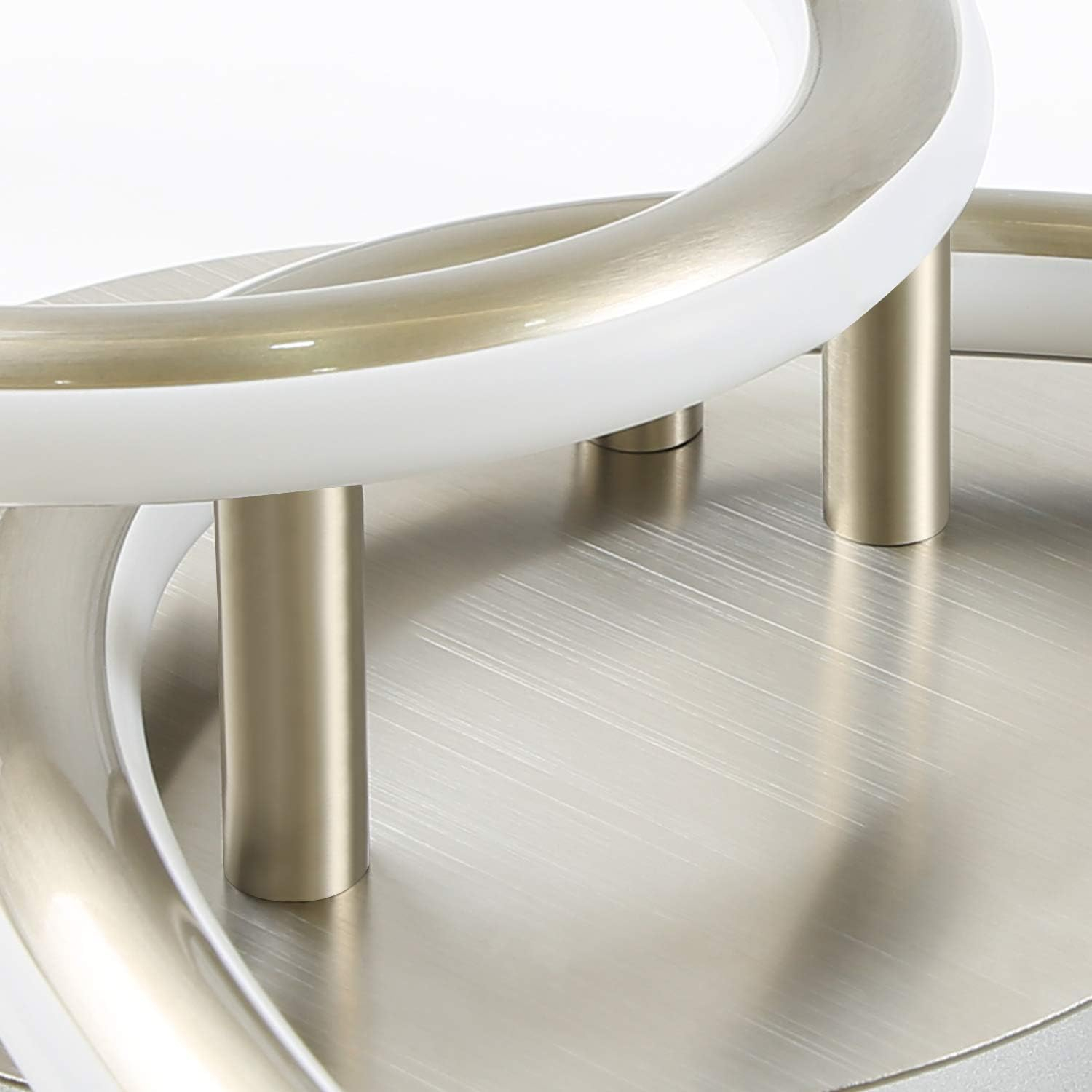 Lampada moderna con bracci metallici curvi e accenti bianchi.