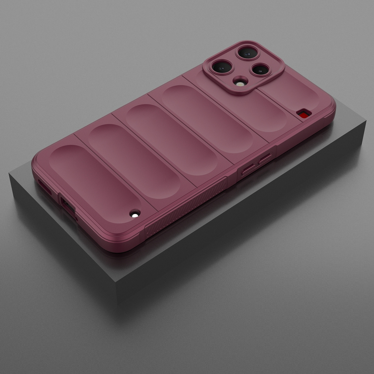 Coque de téléphone bordeaux avec bloc caméra sur socle gris.