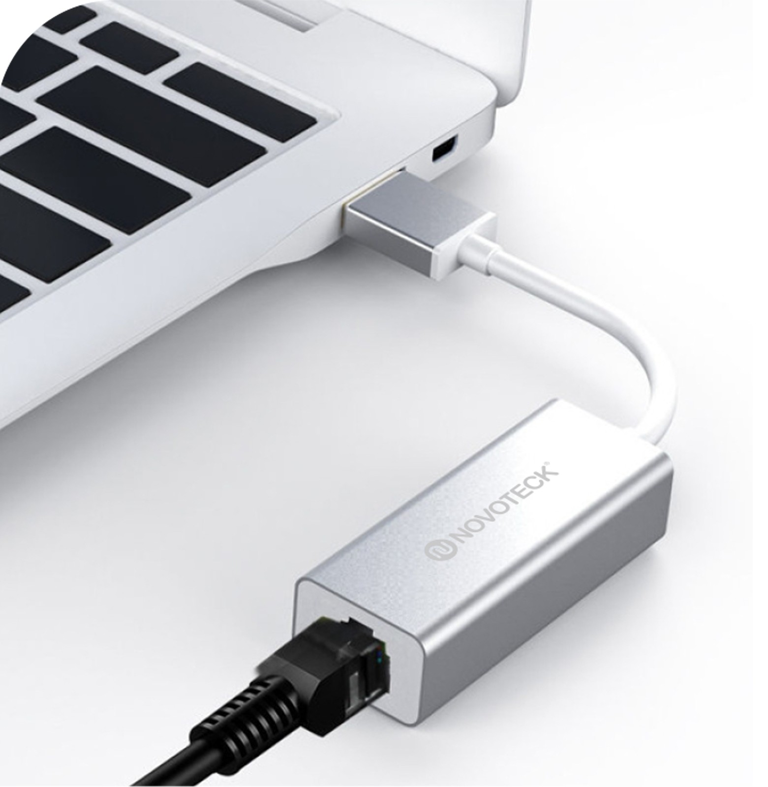 Un adaptador USB-C a Ethernet plateado está conectado a un portátil.