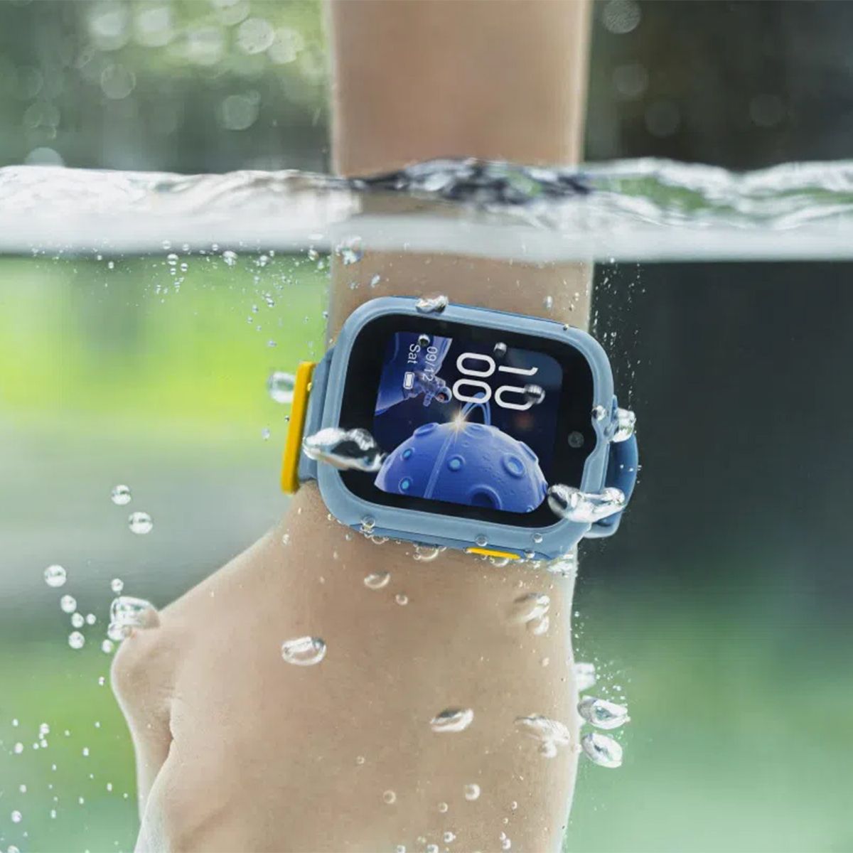 Muñeca de niño lleva un smartwatch azul con correa amarilla, sumergido en agua.