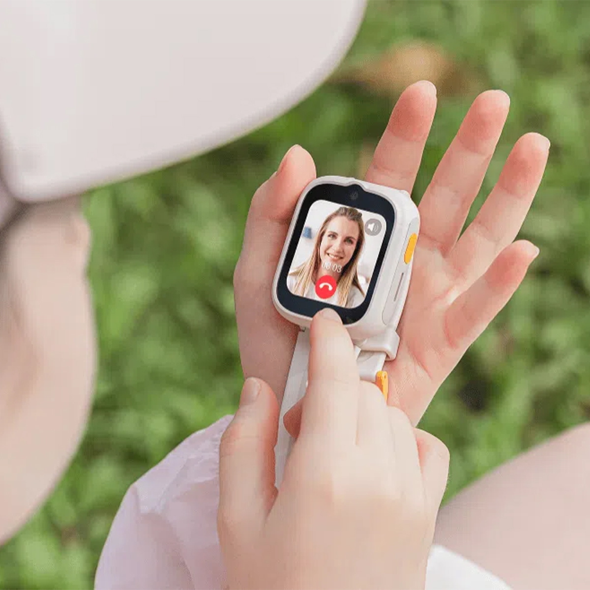 Niño sostiene un smartwatch con videollamada de una mujer.