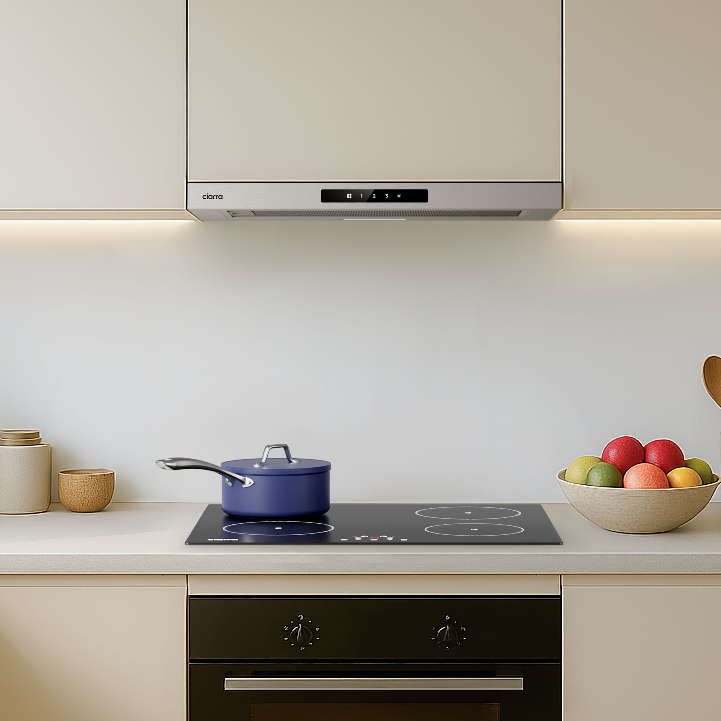 Moderne keuken met inductiekookplaat, pan, fruitschaal en afzuigkap.