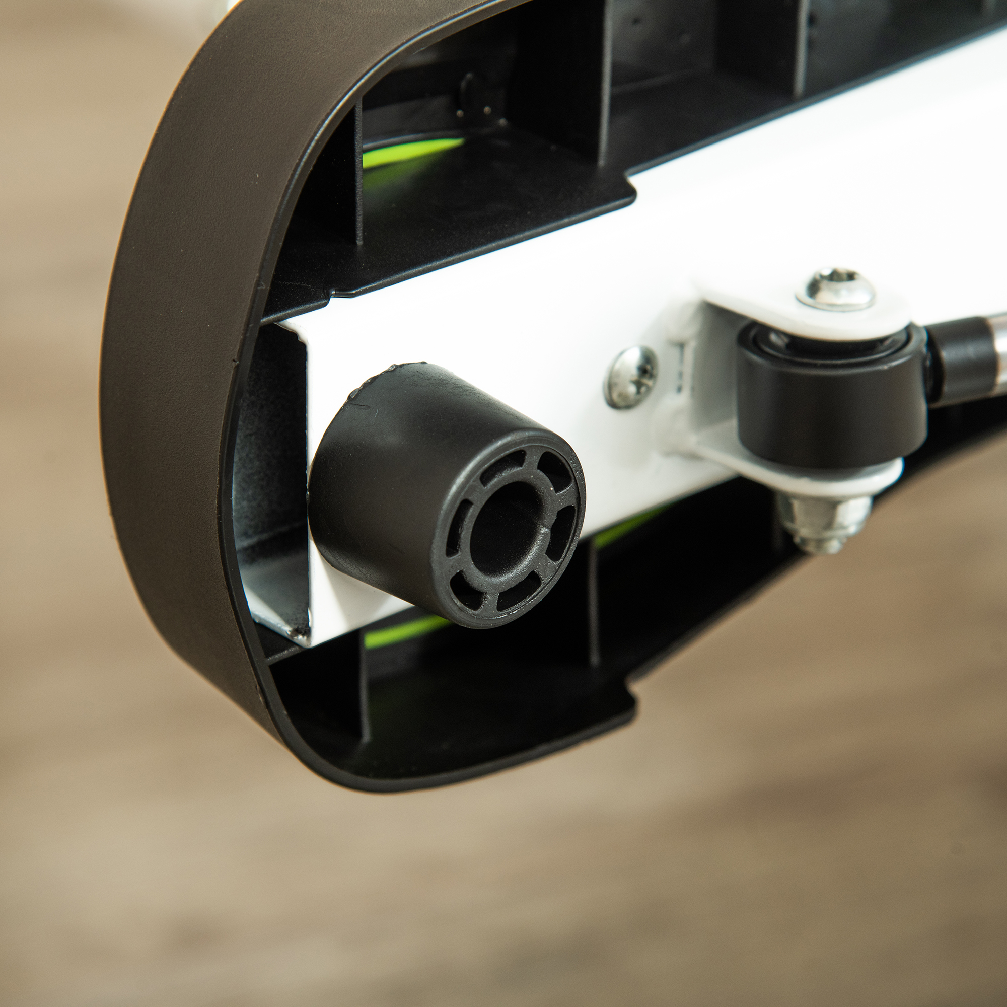 Zbliżenie czarnej gumowej stopki na białej maszynie z metalowymi częściami.