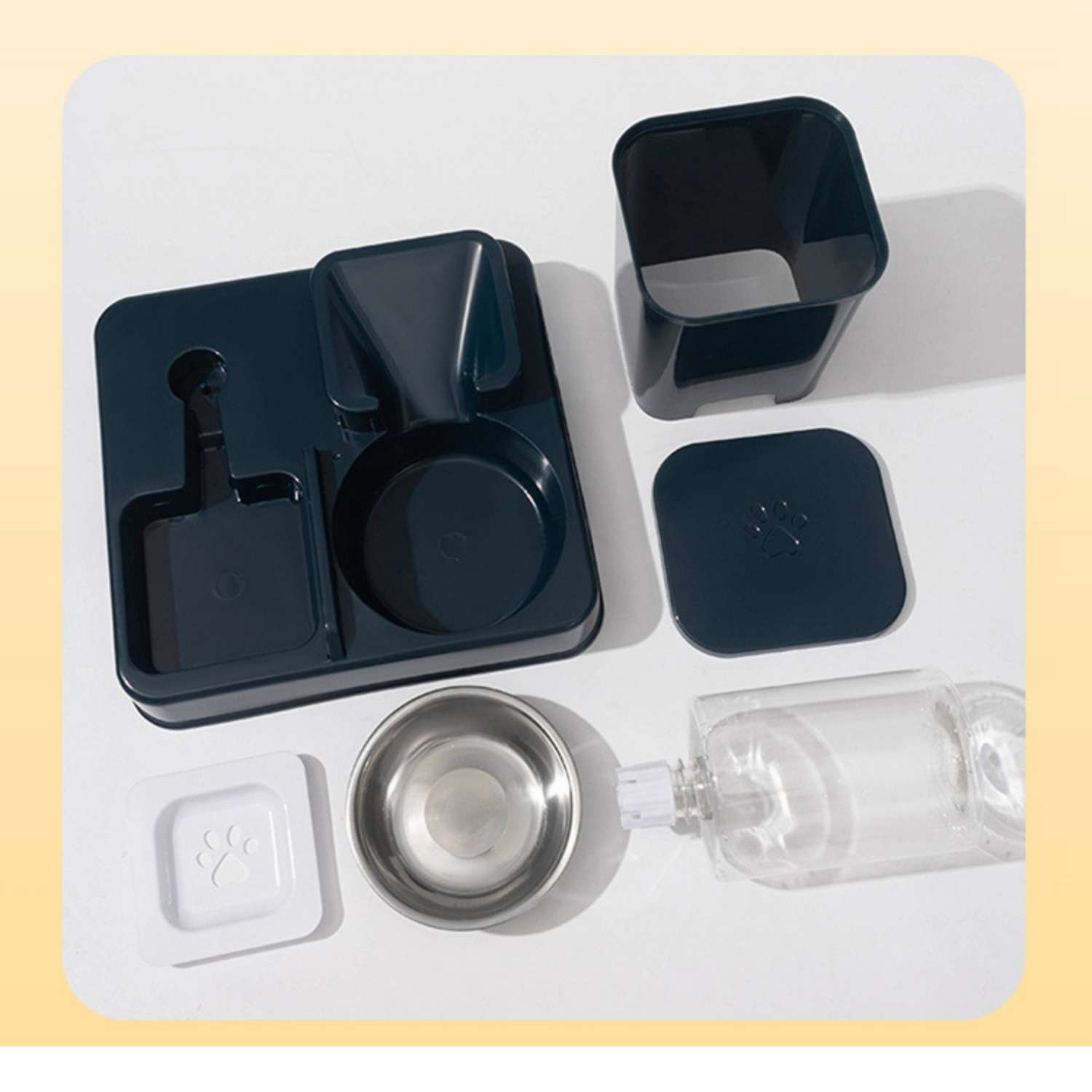 Ein Futternapf-Set aus dunklem Kunststoff mit Metallnapf, weißem Deckel und Flasche.