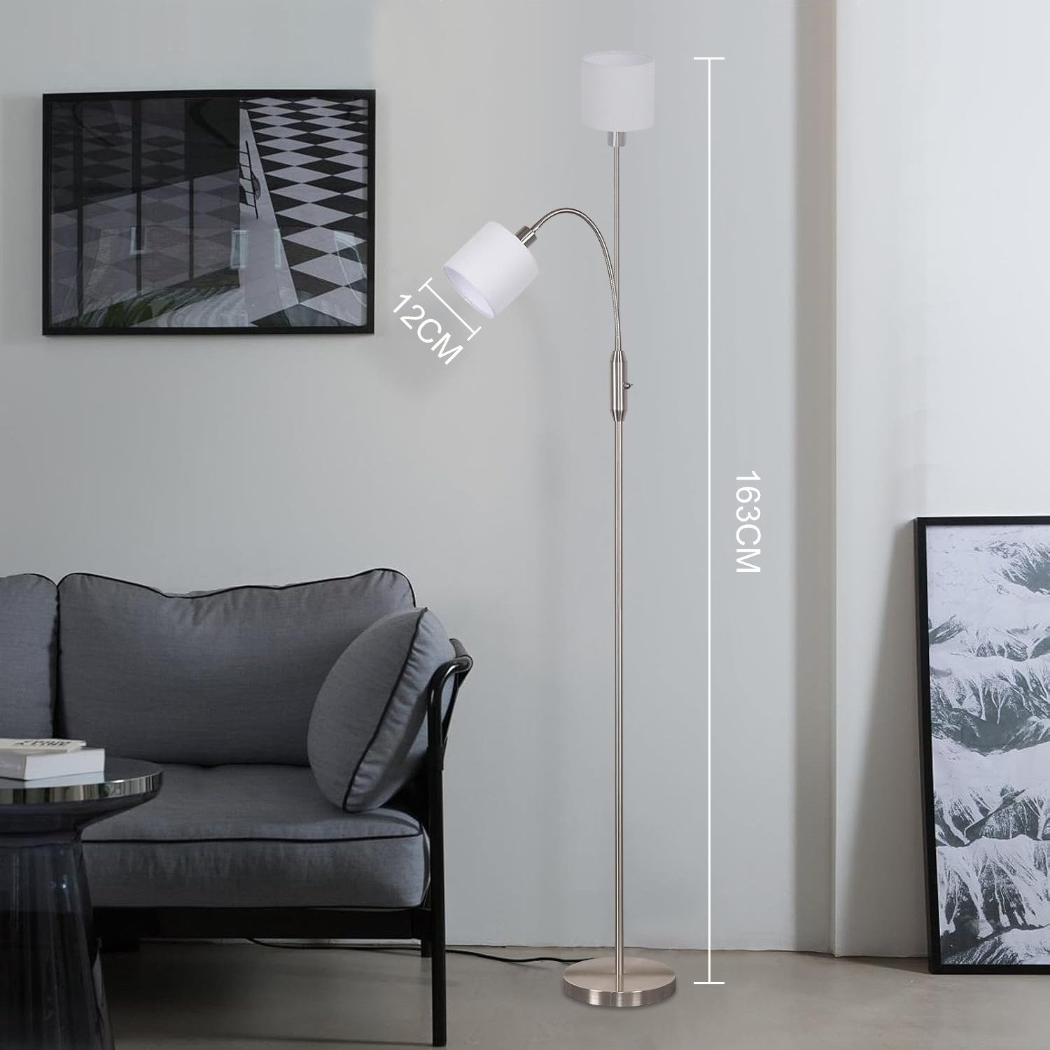 Un moderno lampada da terra a due teste accanto a un divano e arte da parete.