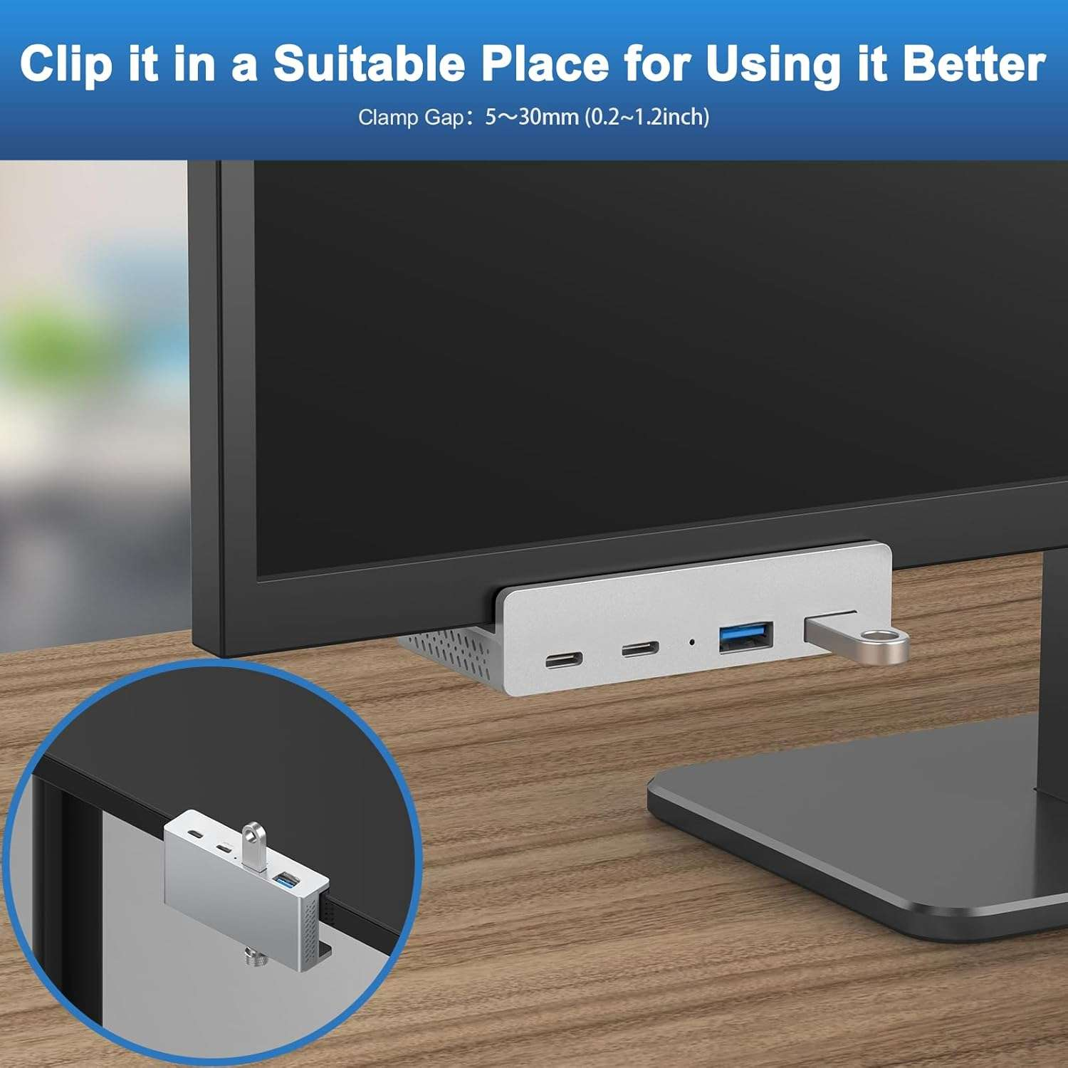 Ein silberner USB-C-Hub mit Anschlüssen ist an der Unterseite eines Monitors befestigt.