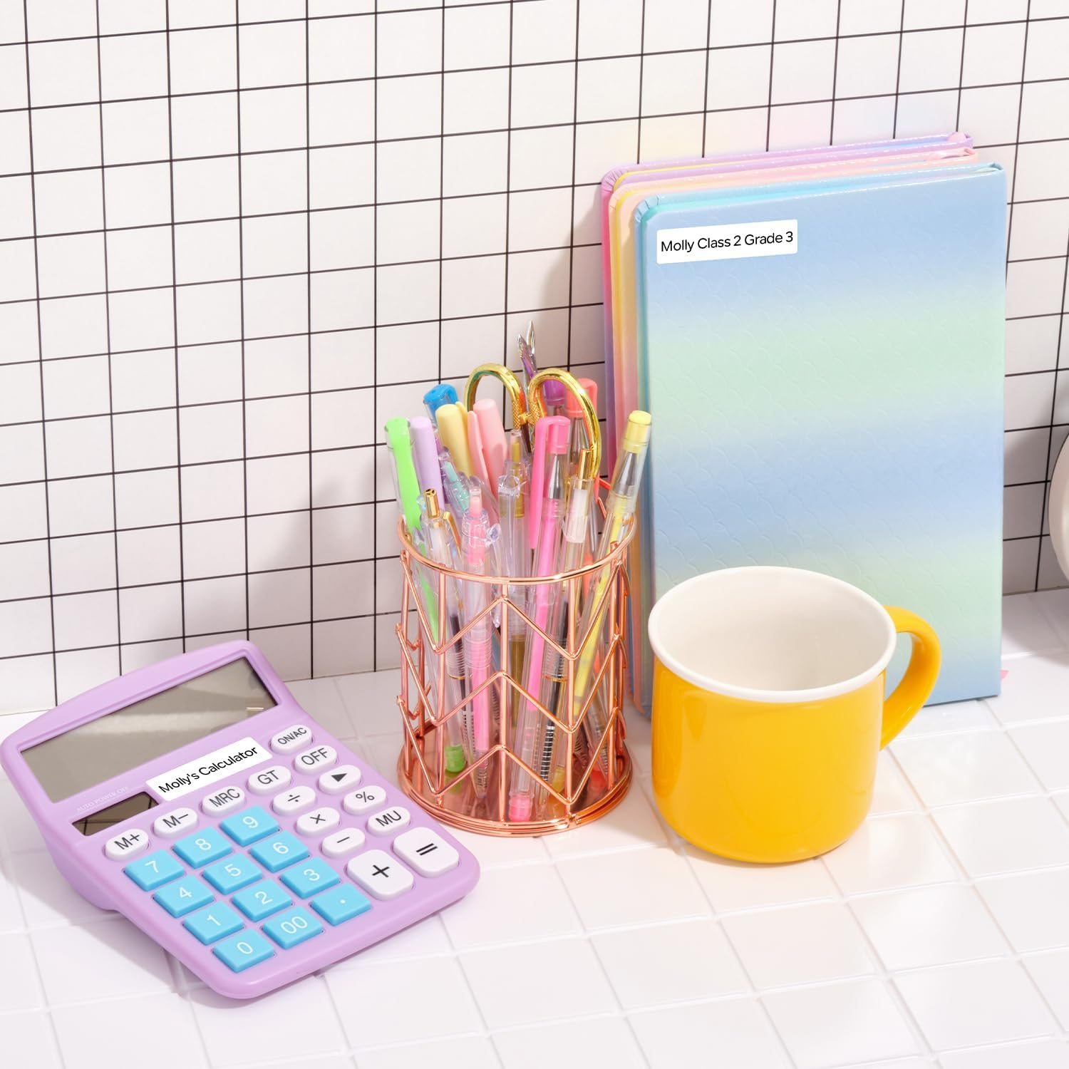 Calculatrice violette, pot à crayons et tasse jaune sur fond quadrillé.