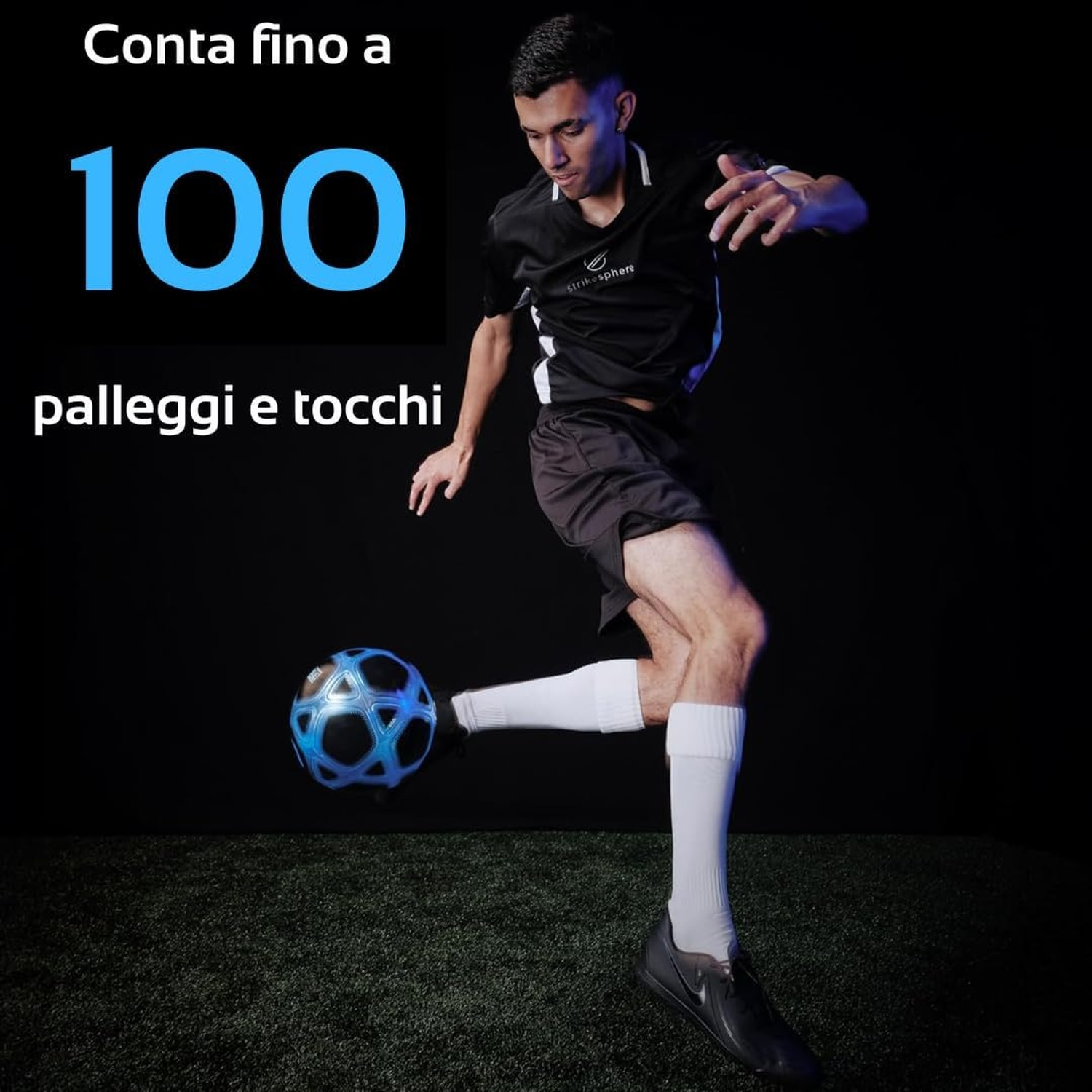 Un uomo gioca a calcio, colpendo una palla blu su erba sintetica verde.