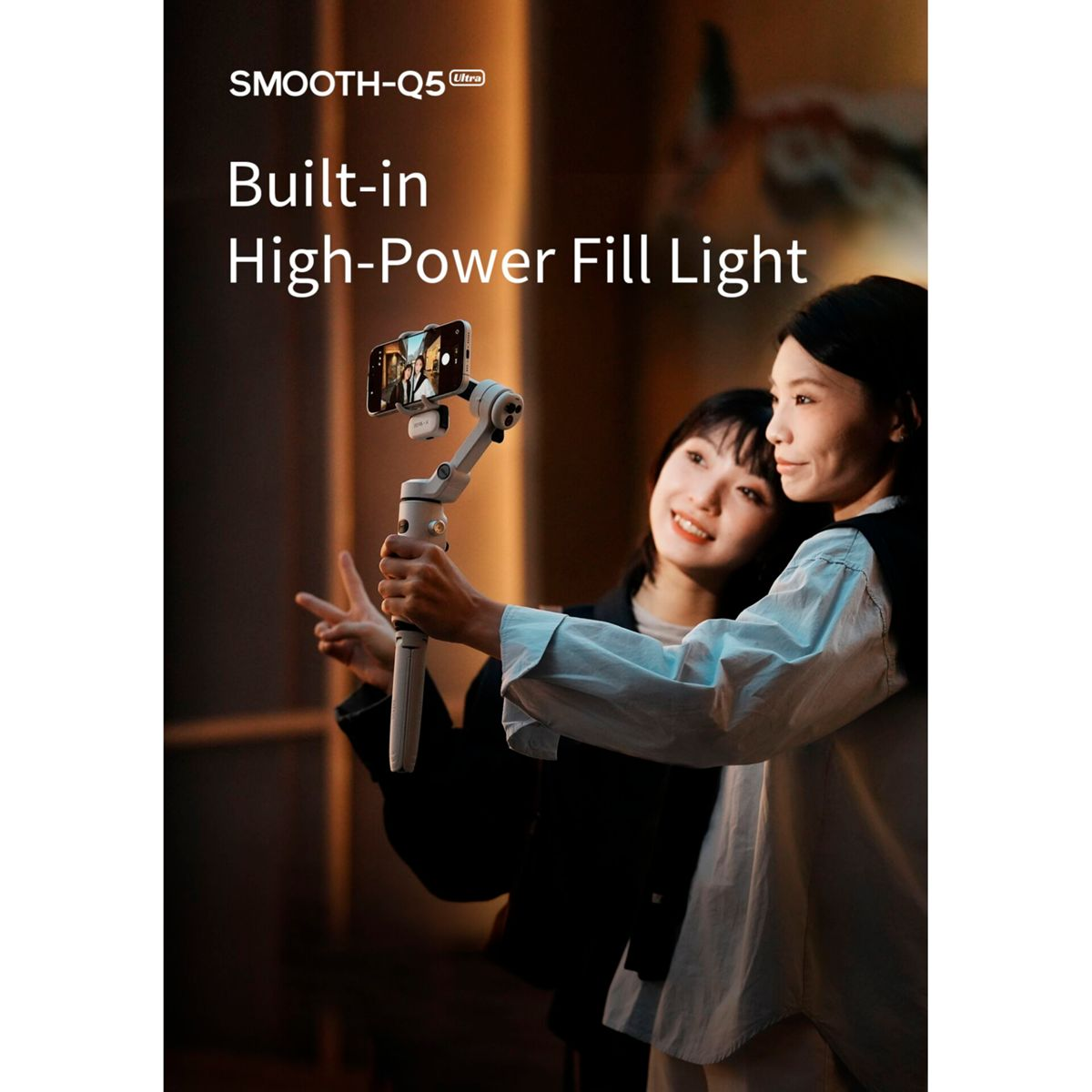Zwei Frauen machen ein Selfie mit einem Gimbal und Handy. Der Gimbal hat ein integriertes Licht.