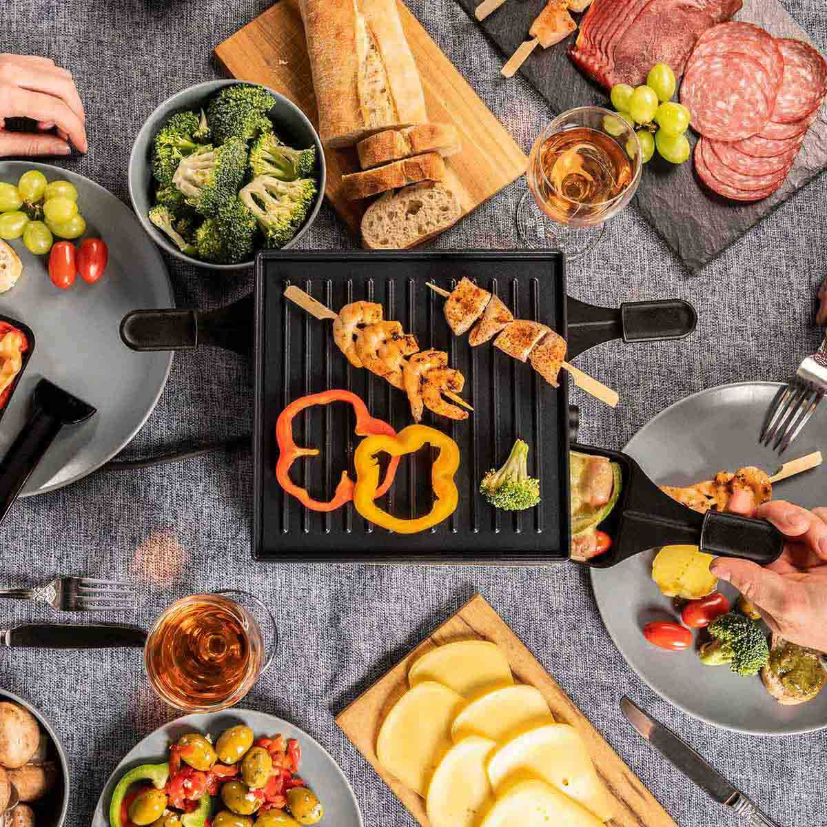 Raclette mit Garnelen, Hähnchen, Paprika, Brokkoli, Brot, Wein und Wurst.