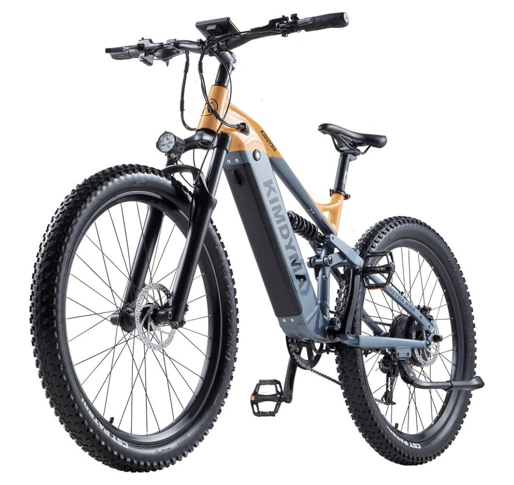 Una bici elettrica grigia e gialla con pneumatici larghi, sospensioni e faro.