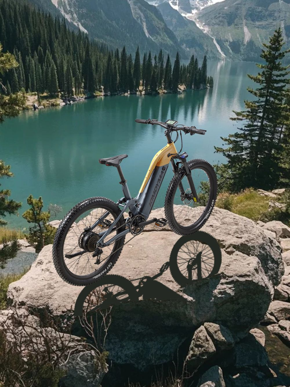 Una e-bike gialla riposa su una roccia, con lago e montagne sullo sfondo.