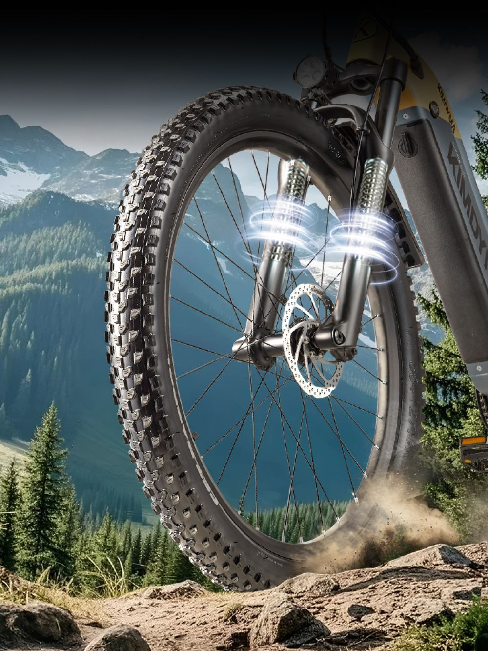 Primo piano di una bici con copertoni larghi che solleva polvere, con montagne sullo sfondo.