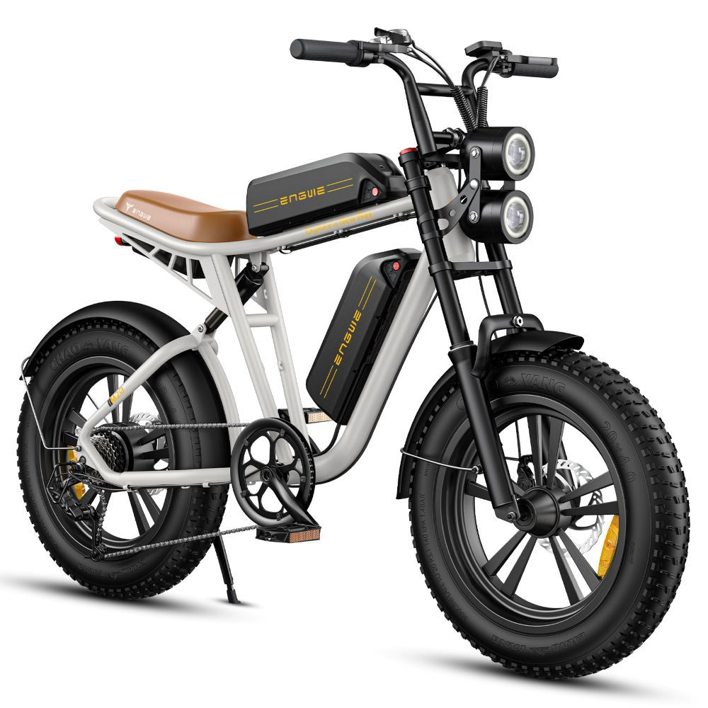 Una bici elettrica bianca con sella marrone, doppia batteria e doppio faro.