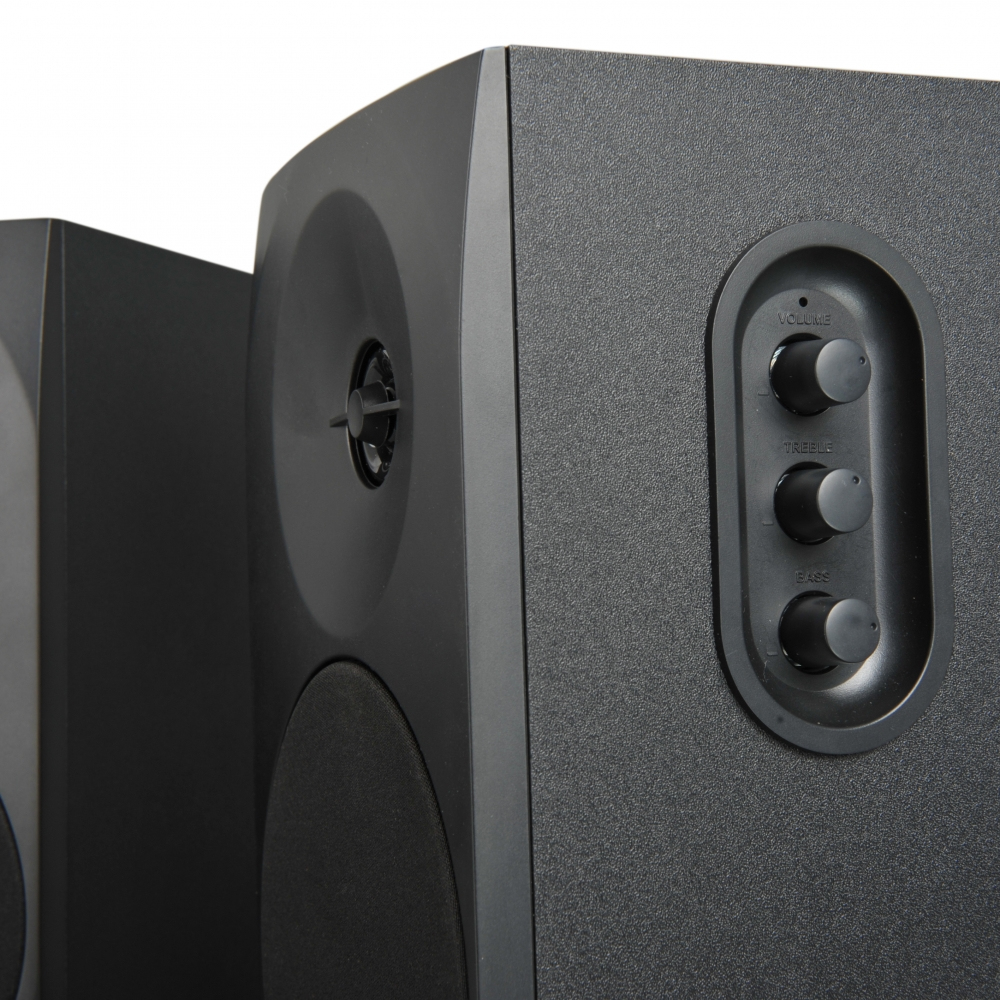 Primer plano de dos altavoces negros con mandos de volumen, agudos y graves.