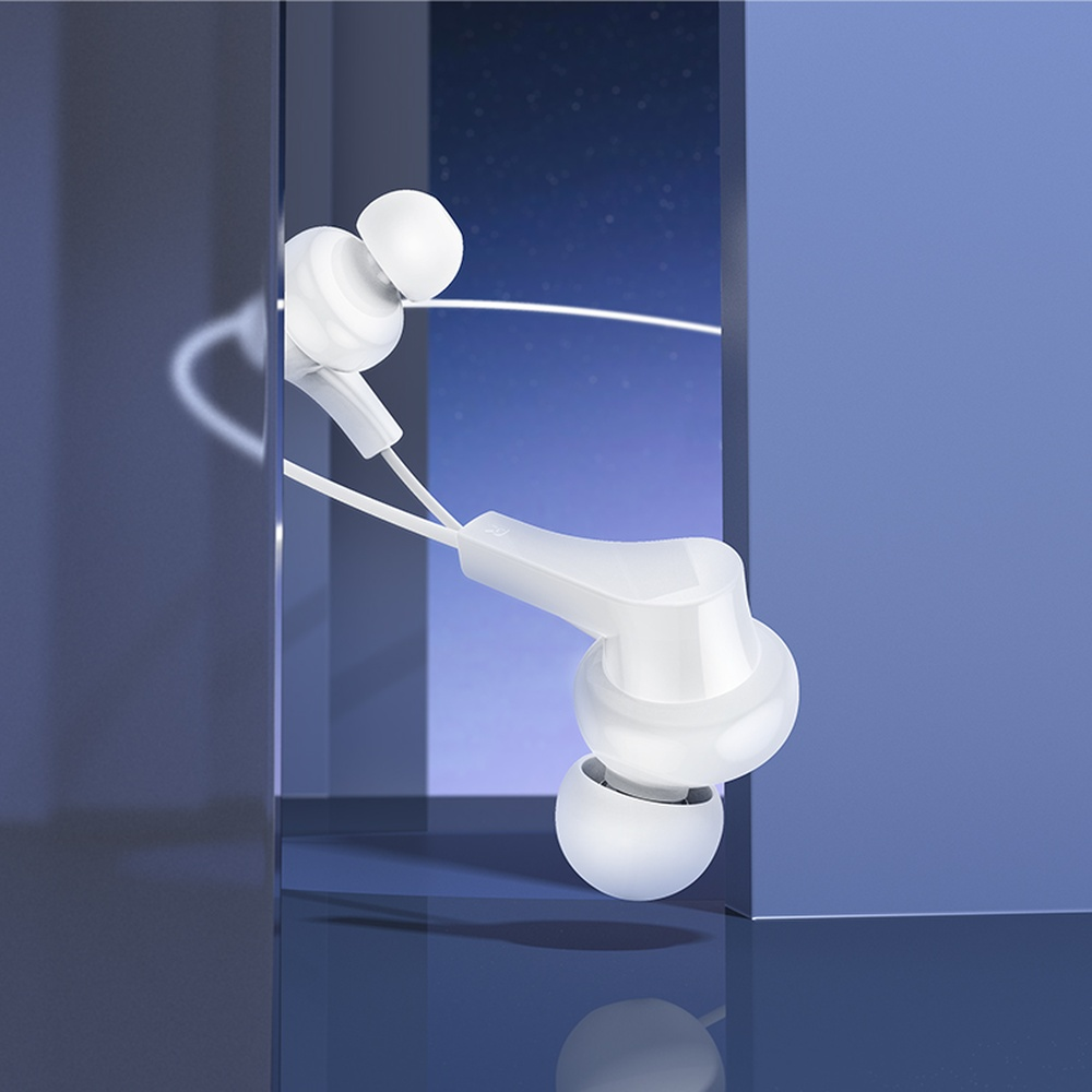 Auriculares blancos con cable en la oreja sobre una superficie azul reflectante.