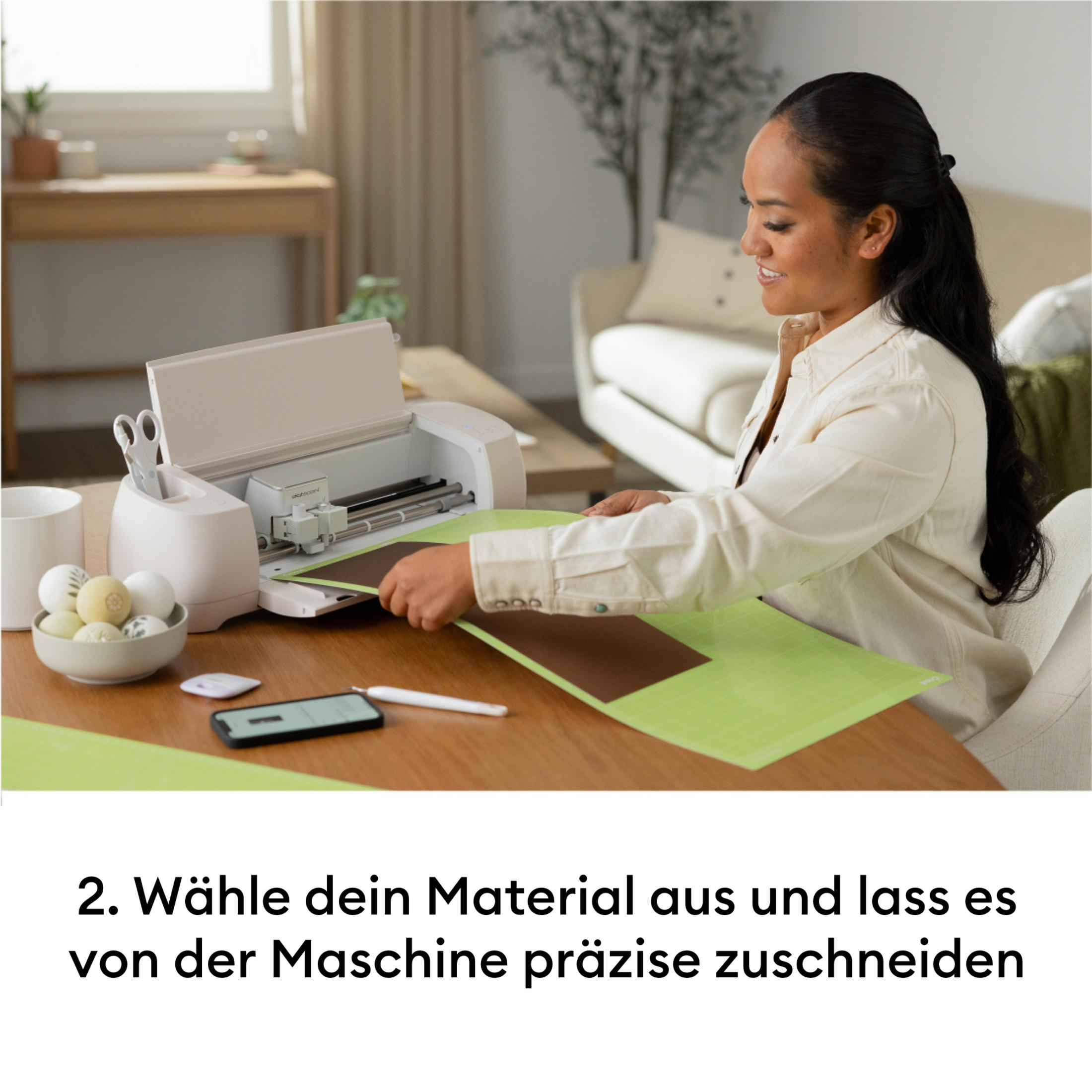 Frau mit Schneidemaschine und braunem Material auf grünem Unterlage.