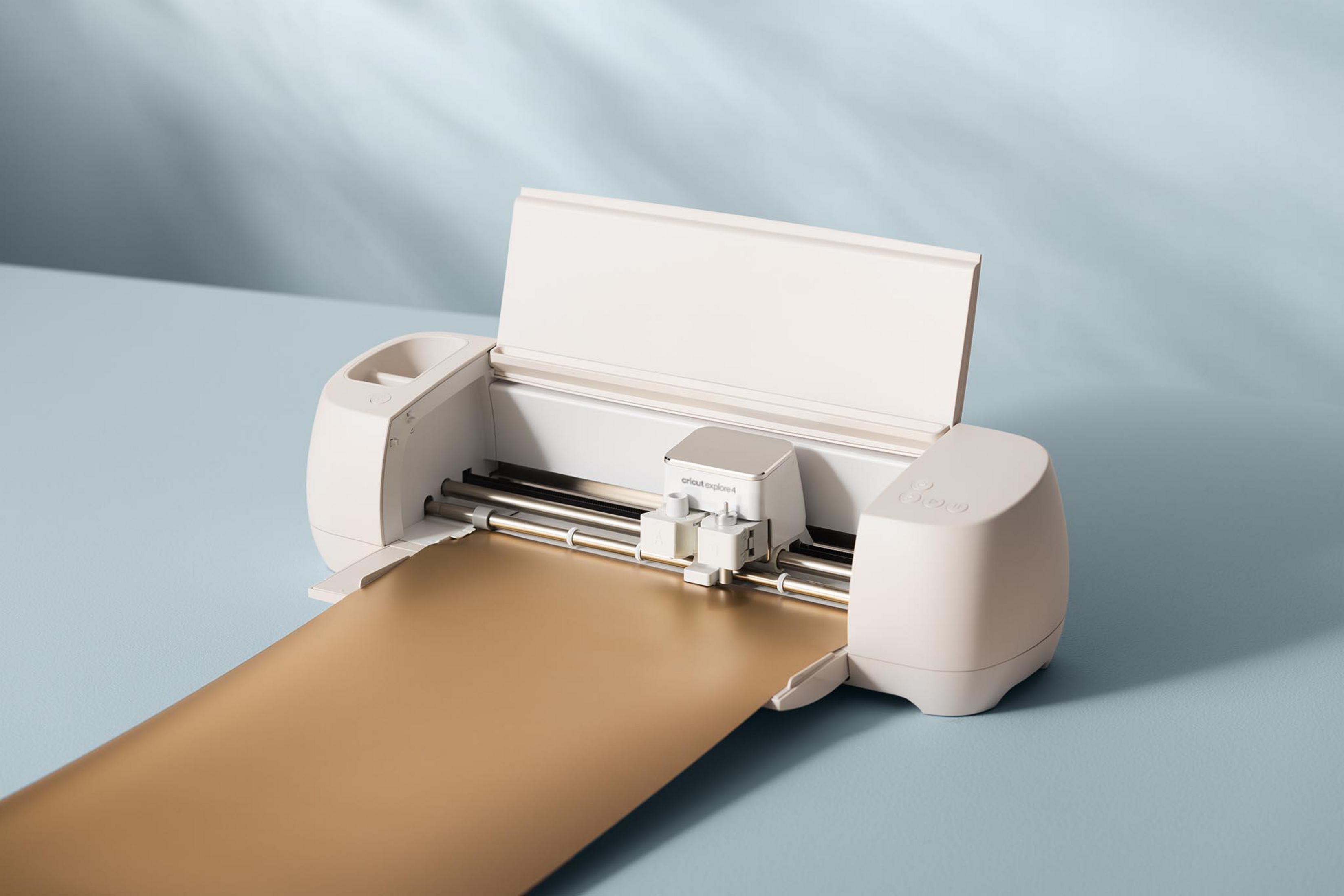 Ein weißer Schneideplotter mit goldener Folie, die eingezogen wird.