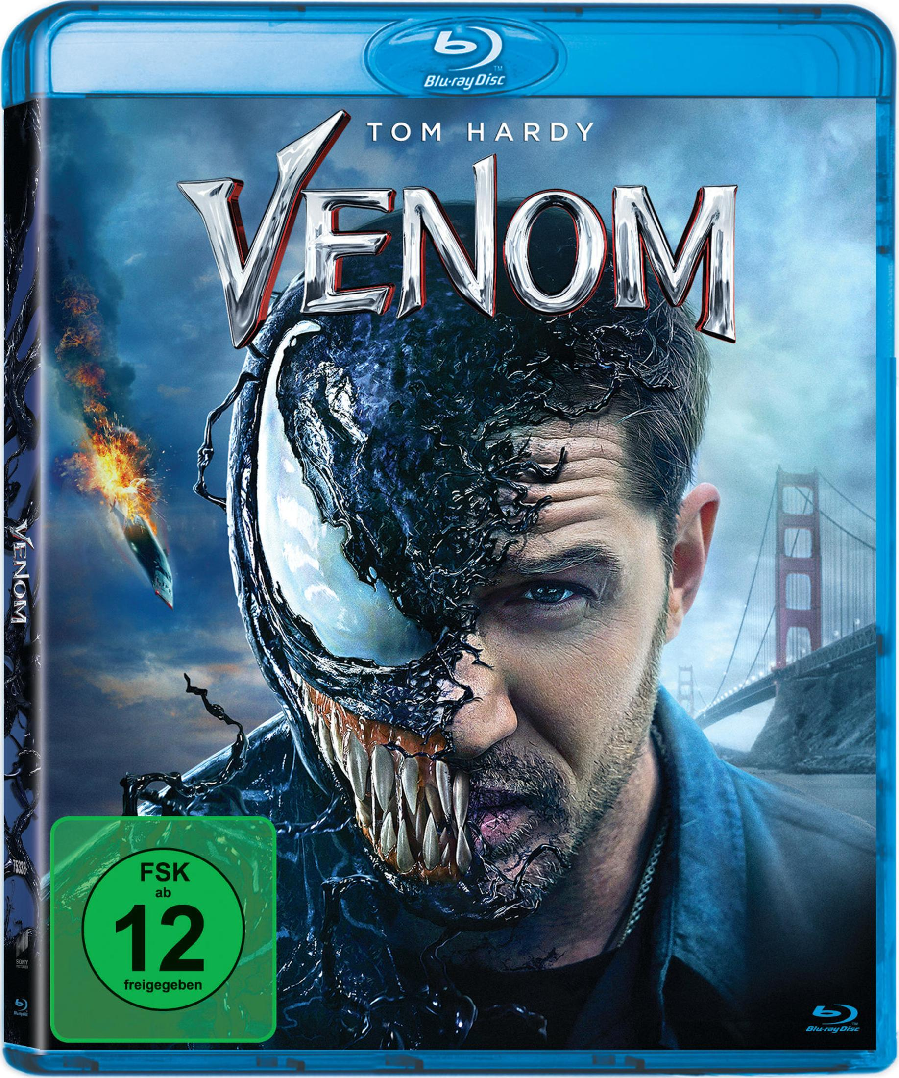 Tom Hardy nei panni di Venom, con denti e tentacoli, davanti a un ponte e un oggetto in fiamme.