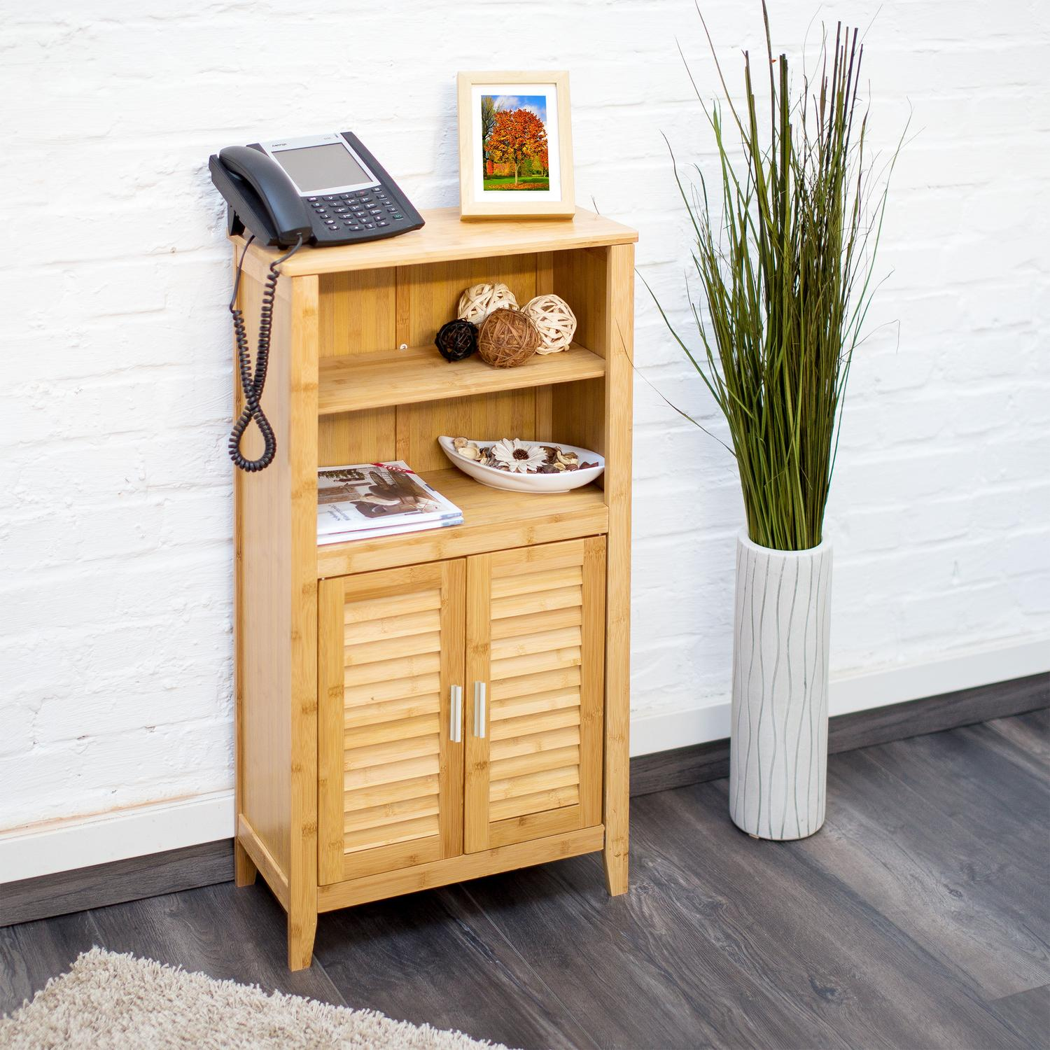 Un mueble de madera con teléfono, cuadro y plantas.