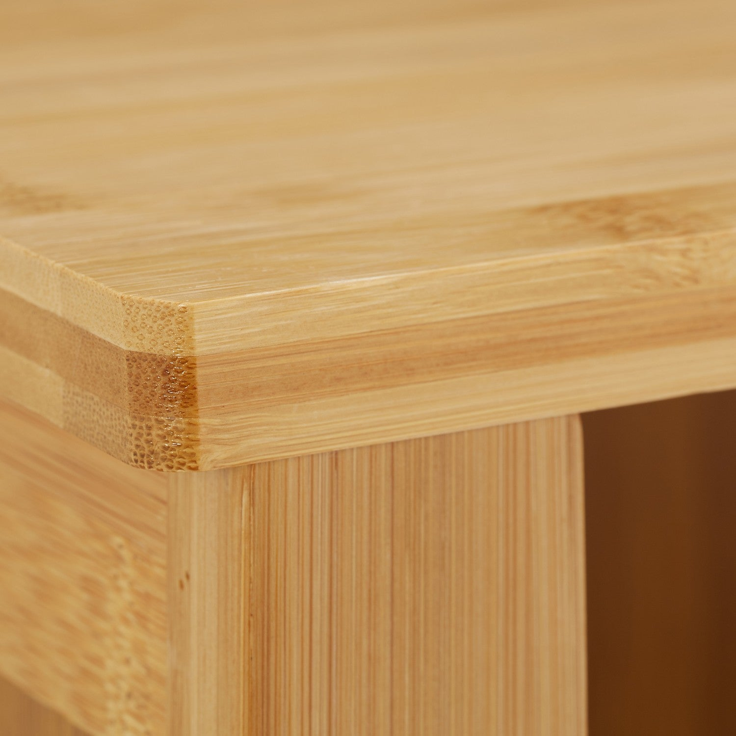 Primer plano de una esquina de madera de bambú clara con veta visible.