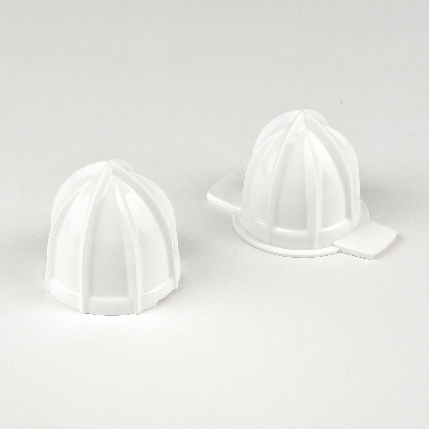 Due accessori bianchi per spremiagrumi su sfondo bianco.