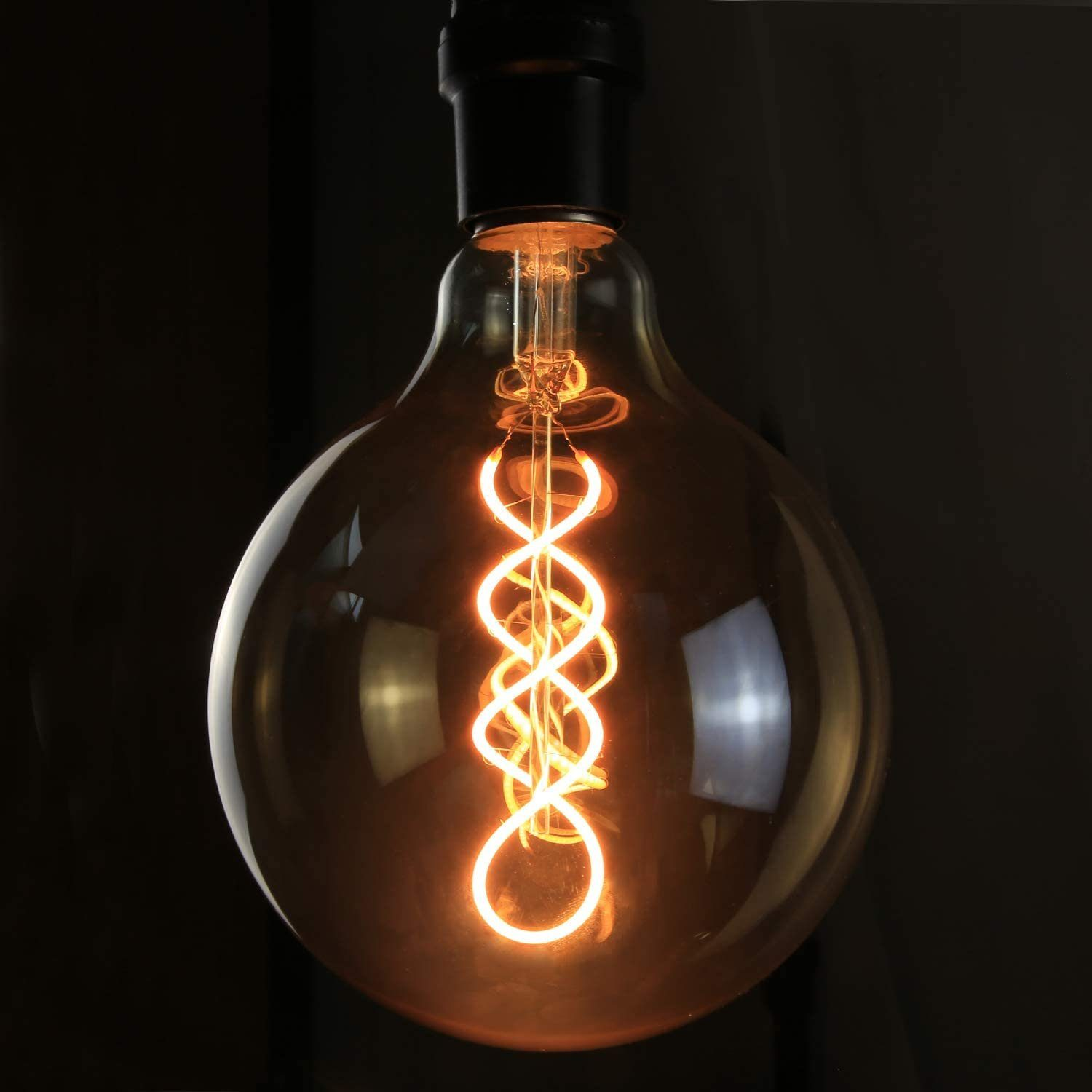 Una lampadina Edison luminosa con filamento a spirale su sfondo scuro.