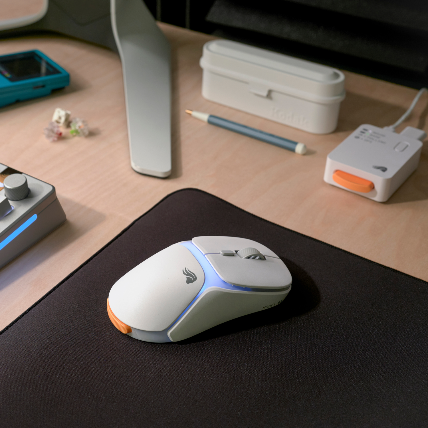 Mavi ışıklı beyaz bir bilgisayar faresi siyah bir mousepad üzerinde duruyor.