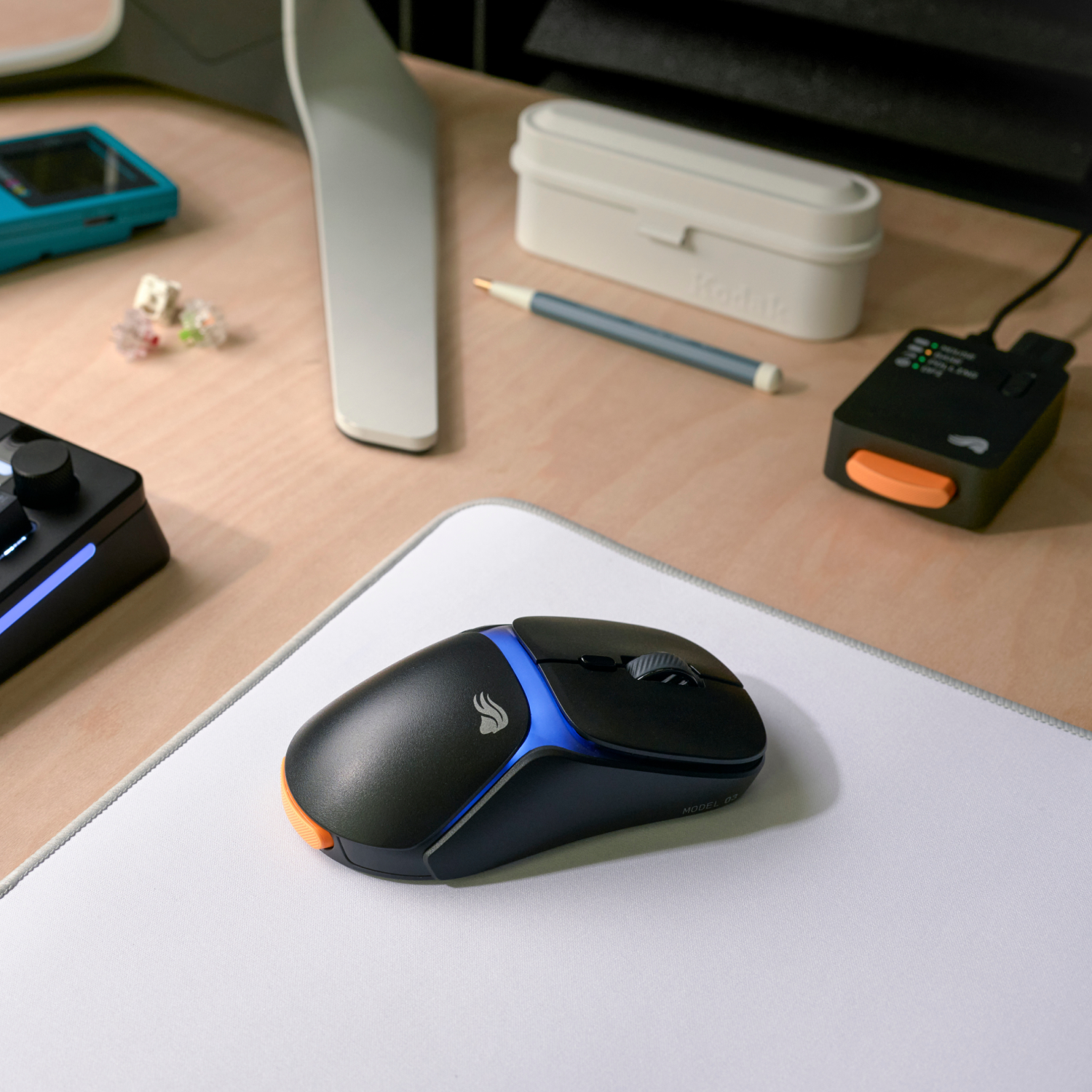 Beyaz mousepad üzerinde mavi ve turuncu vurgulu siyah fare.